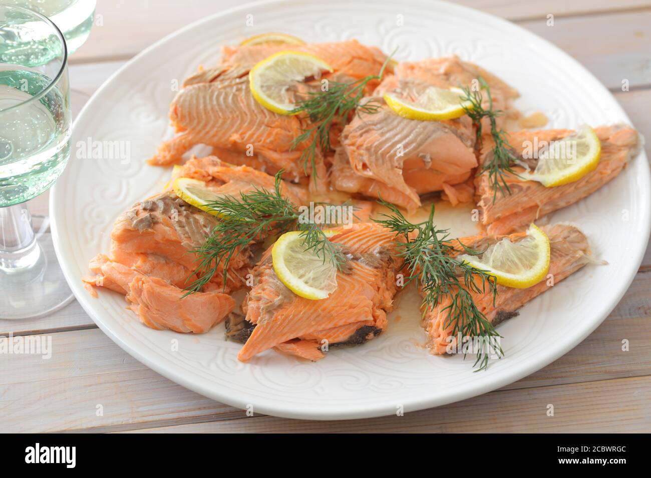 Gebackener Forellenfisch serviert mit Zitronenscheiben und Dill Stockfoto