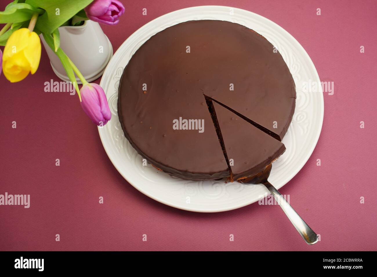 Schokoladenkuchen und ein Strauß Tulpenkuchen, Schokolade, Scheibe, Strauß, braun, Geburtstag, flaches Lay, Overhead, floral Stockfoto