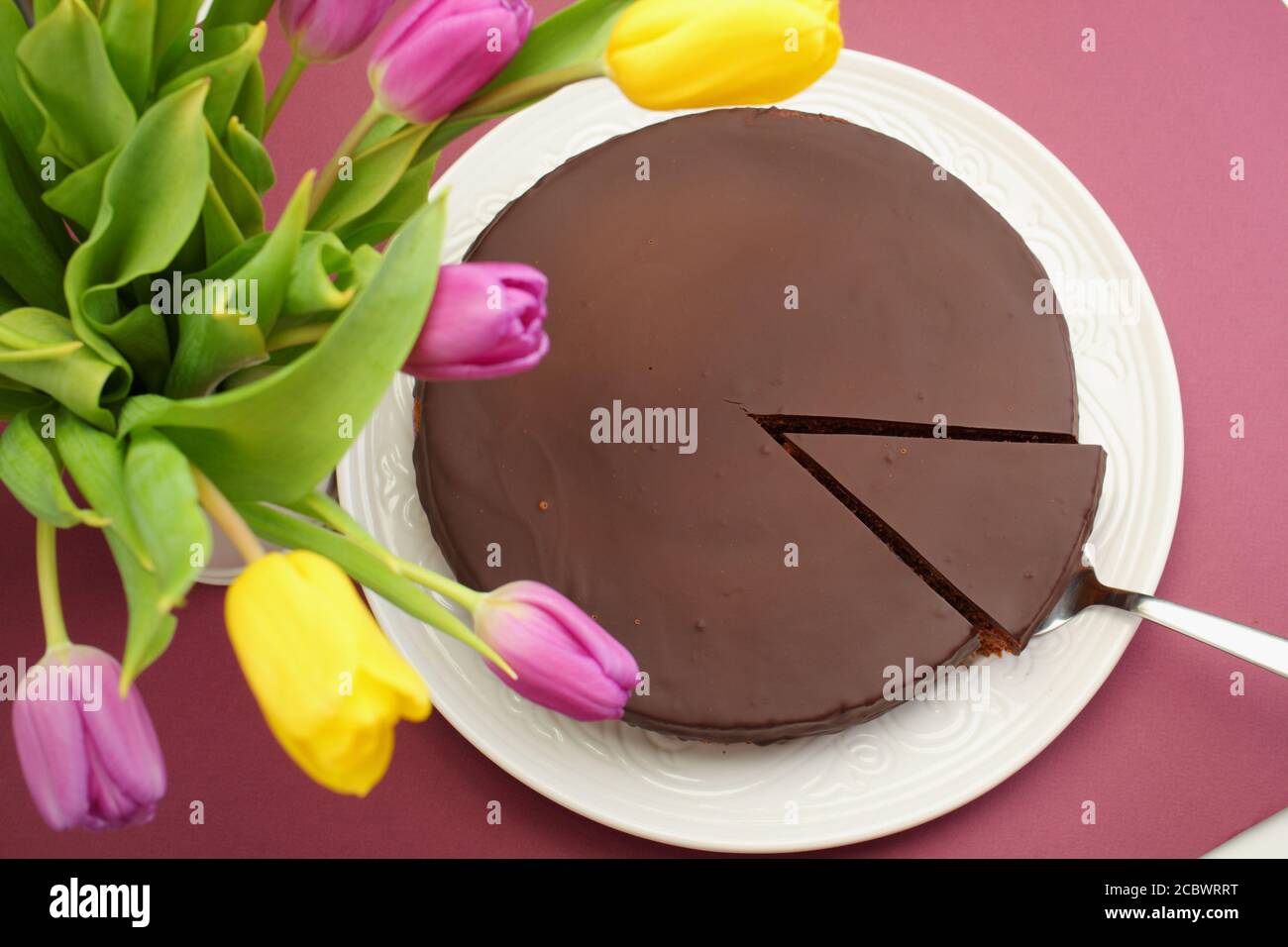 Schokolade Kuchen und einen Blumenstrauß aus Tulpen Stockfoto