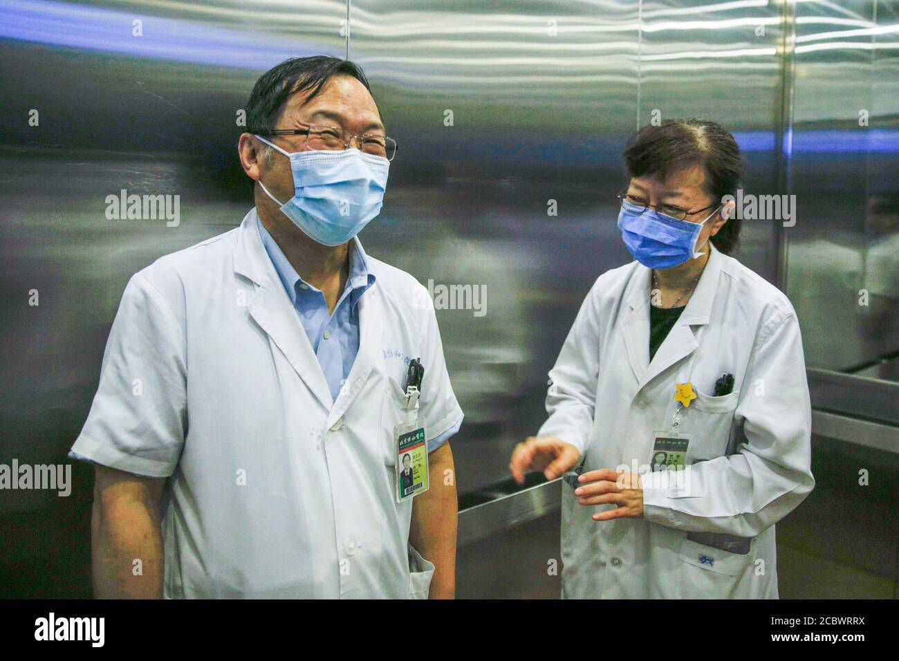 (200816) -- PEKING, 16. August 2020 (Xinhua) -- Liu Zhengyin (L), leitender Arzt und Doktorvater der Infektionsabteilung des Peking Union Medical College Hospital (PUMCH), spricht mit seinem Kollegen bei PUMCH in Peking, Hauptstadt von China, 14. August 2020. Liu war während des COVID-19-Ausbruchs Leiter des ersten medizinischen Hilfsteams von PUMCH in Wuhan. Nach der Ankunft in Wuhan im Januar hat das Ärzteteam für COVID-19-Patienten allgemeine Stationen und eine Intensivstation eingerichtet. Liu gehörte zu der ersten Gruppe von Ärzten, die die Stationen betraten und sich direkt mit den Patienten kontaktierten. Stockfoto