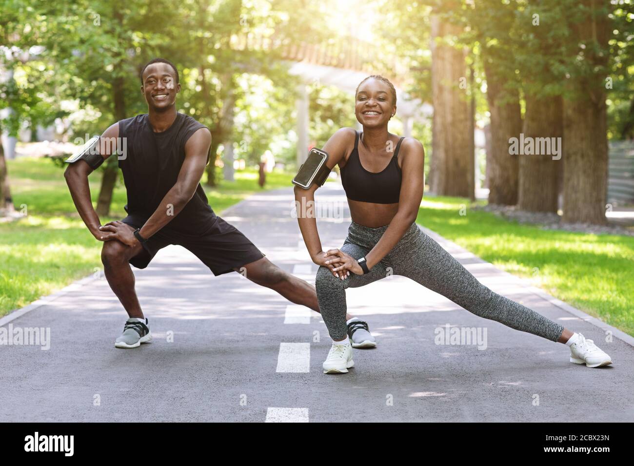 Black Runner Paar Stretching Muskeln Im Freien, Aufwärmen Vor Dem Joggen Im  Park Stockfotografie - Alamy