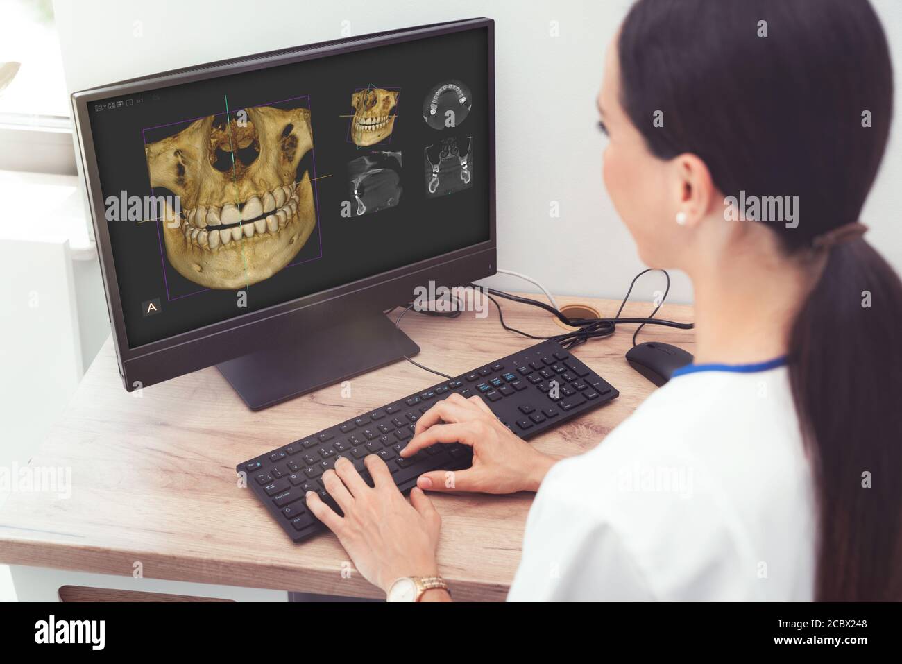 Zahnärztin schaut sich ein Foto des 3D-Tomographen an. Behandlung, Schutz, Gesundheitsversorgung für Zähne Stockfoto