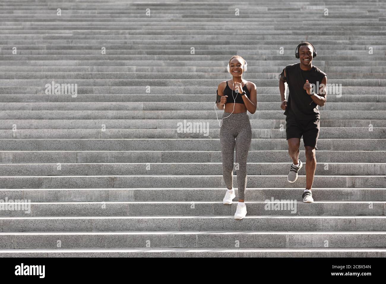 Aktiver Lebensstil. Schwarzes Jogger-Paar, Das Auf Städtischen Treppen Herunterläuft, Training Im Freien Stockfoto