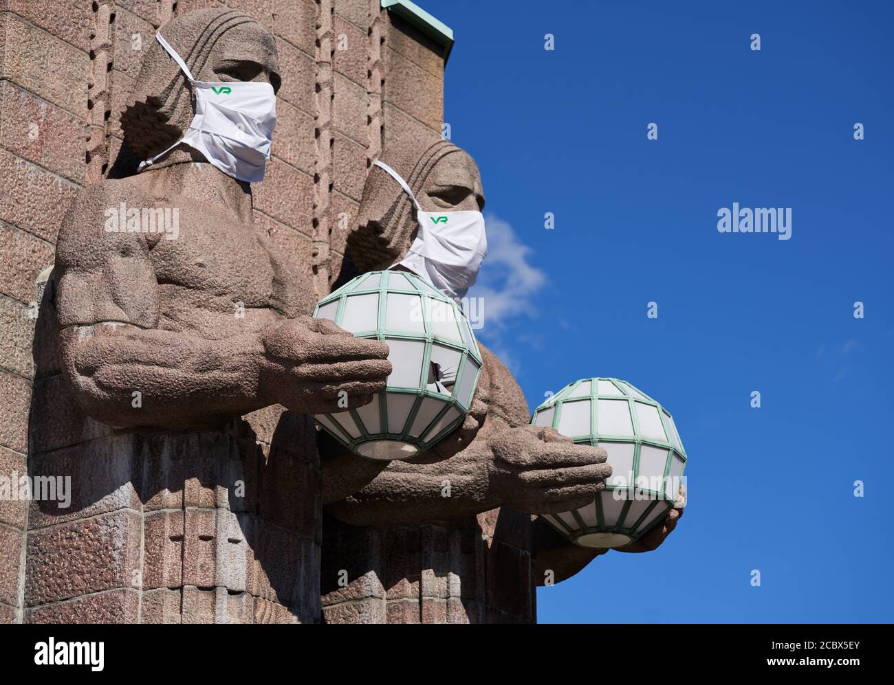 Helsinki, Finnland - 16. August 2020: Ikonische Männer Statuen an der Seite des Eingangs zum Hauptbahnhof von Helsinki dekoriert als tragen Stockfoto