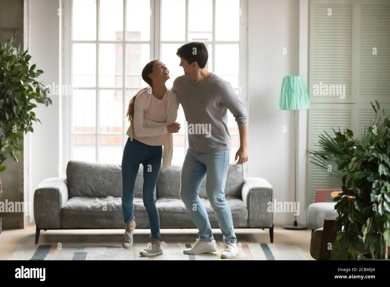 Verrücktes Millennial-Familienpaar, das zu Disco-Musik tanzt. Stockfoto