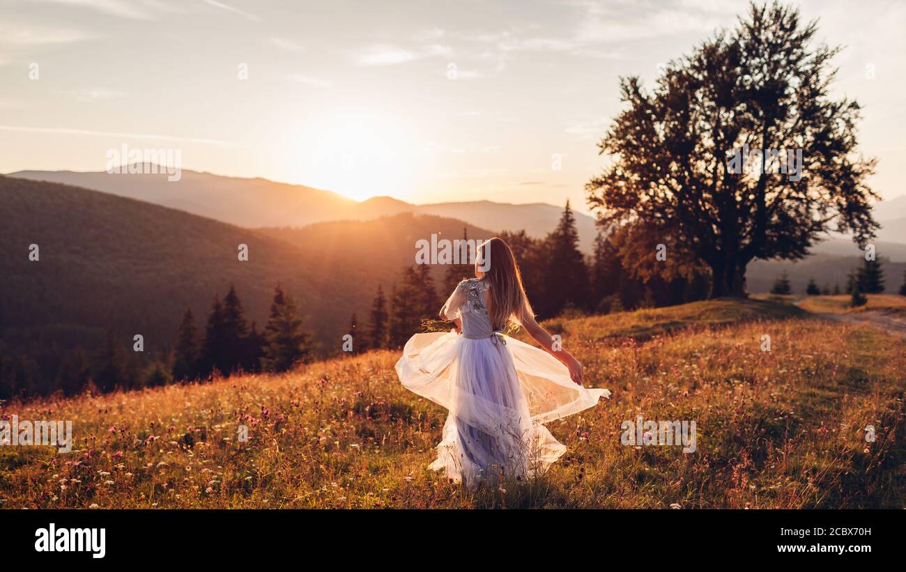 Schone Braut Tanzen In Blauen Hochzeitskleid In Den Bergen Bei Sonnenuntergang Frau Geniesst Landschaft Halten Kleid Stockfotografie Alamy
