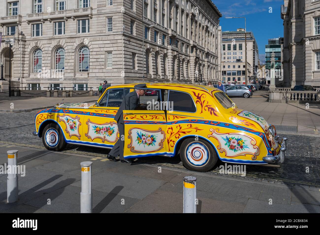 Mehrfarbige Vintage Rolls Royce Limousine zieht Touristen in Liverpool, Merseyside, Großbritannien an Stockfoto