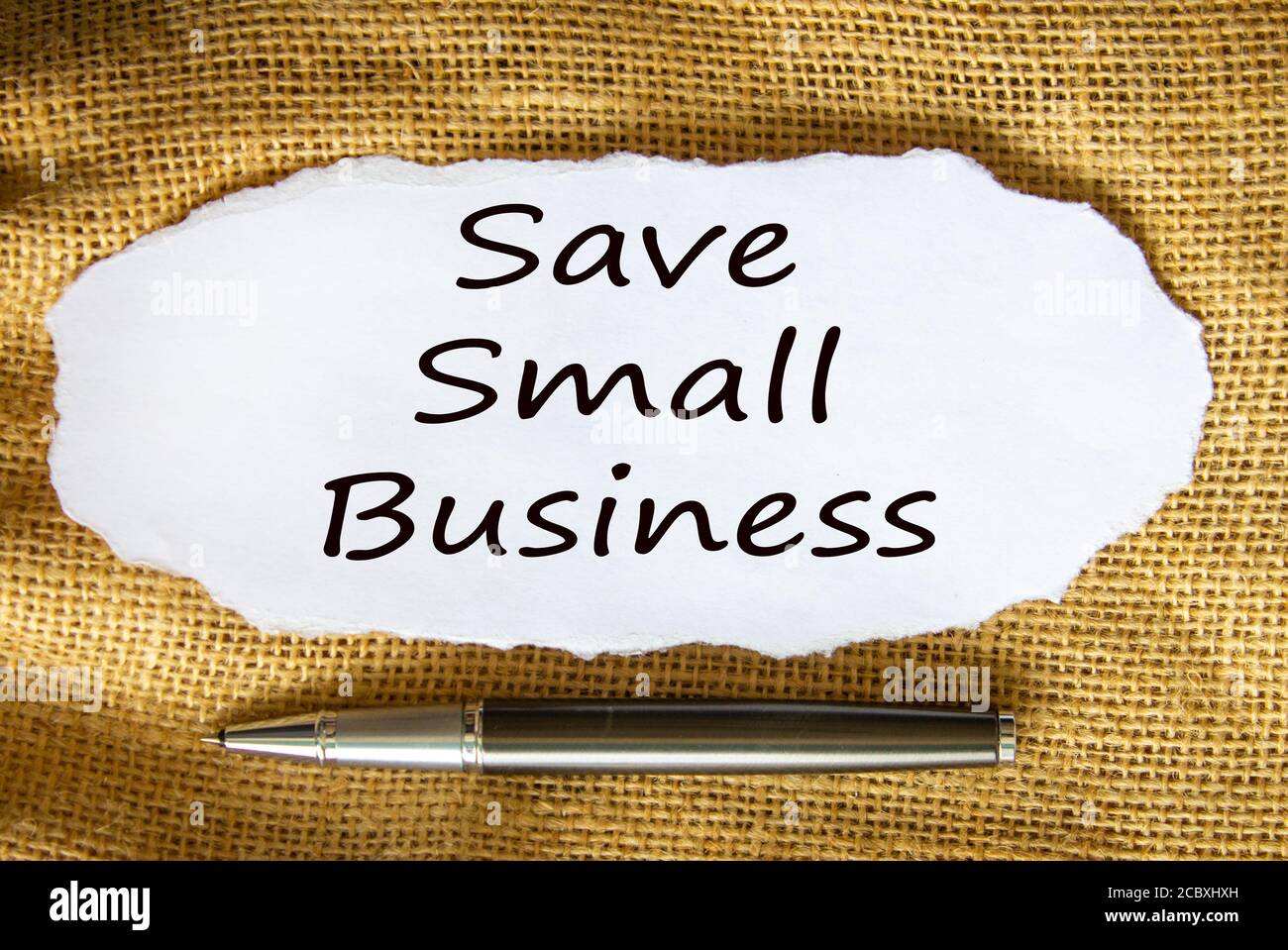 Der Text „Save Small Business“ auf White Paper. Metallstift. Schöner Leinwandhintergrund. Geschäftskonzept. Stockfoto