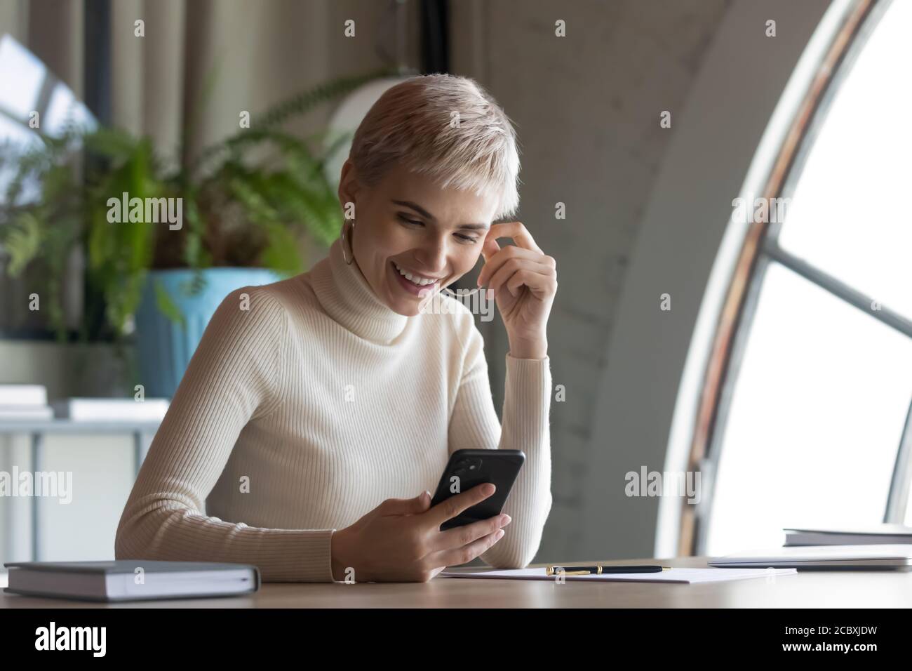 Glückliche junge Geschäftsfrau mit mobilen Software-Anwendung. Stockfoto