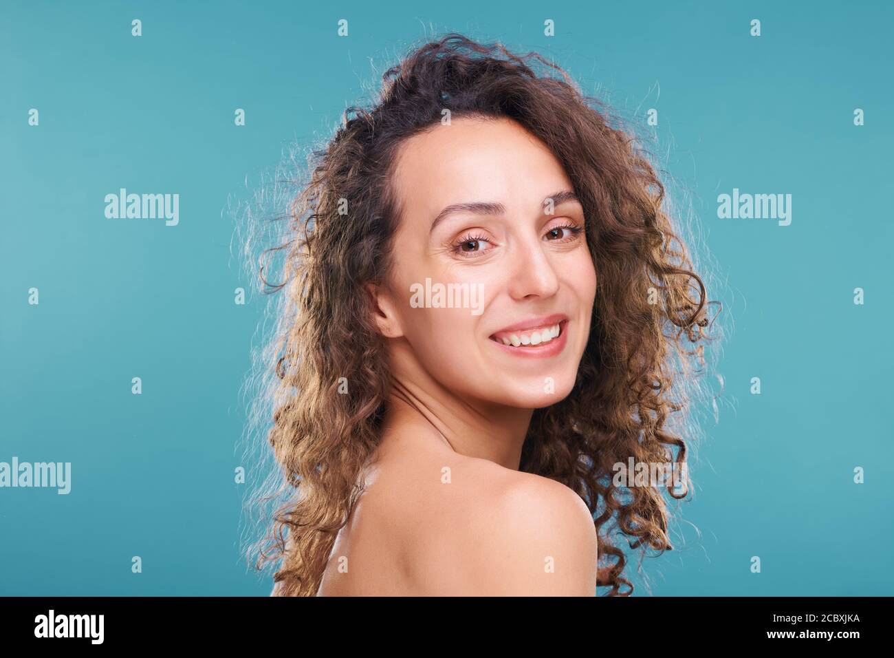 Fröhliche junge Frau mit gesunder Haut und toothy Lächeln suchen Bei der Kamera Stockfoto