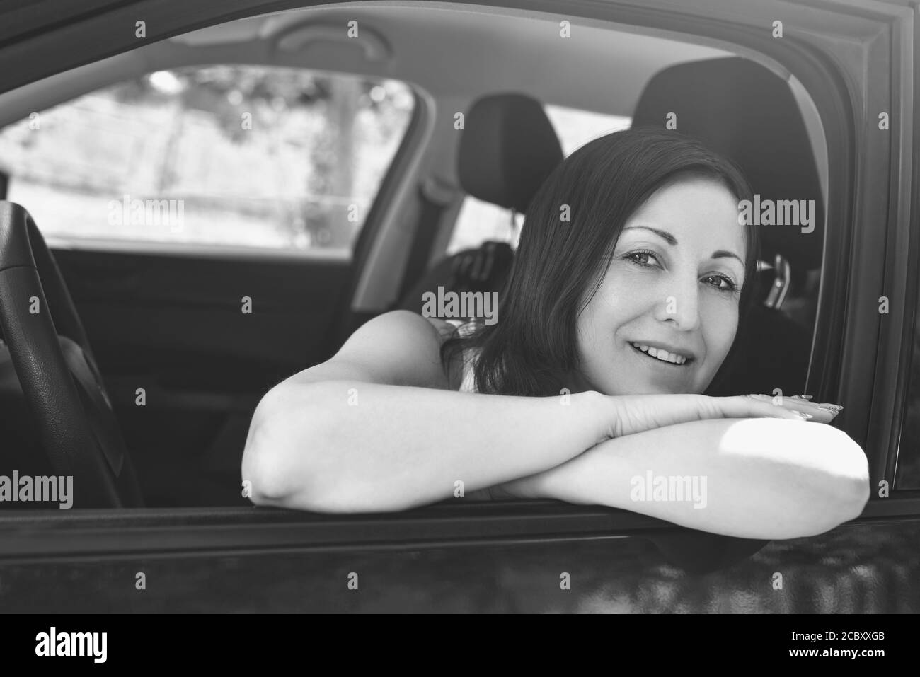 Lächelnd weibliche Fahrer Blick aus dem Auto Stockfoto