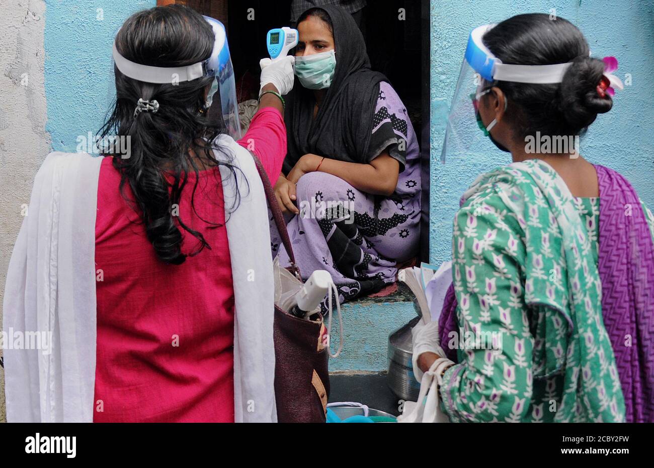 Gesundheitsarbeiter trägt ein Gesicht Sheild Kontrollen Temperatur einer Frau.Coronavirus bestätigte Fälle im Land haben 25.89 lakh nach Union Health Ministry erreicht. Sie verzeichnete 63,000 neue Fälle und ist nach den USA und Brasilien am drittstärksten betroffen. Stockfoto