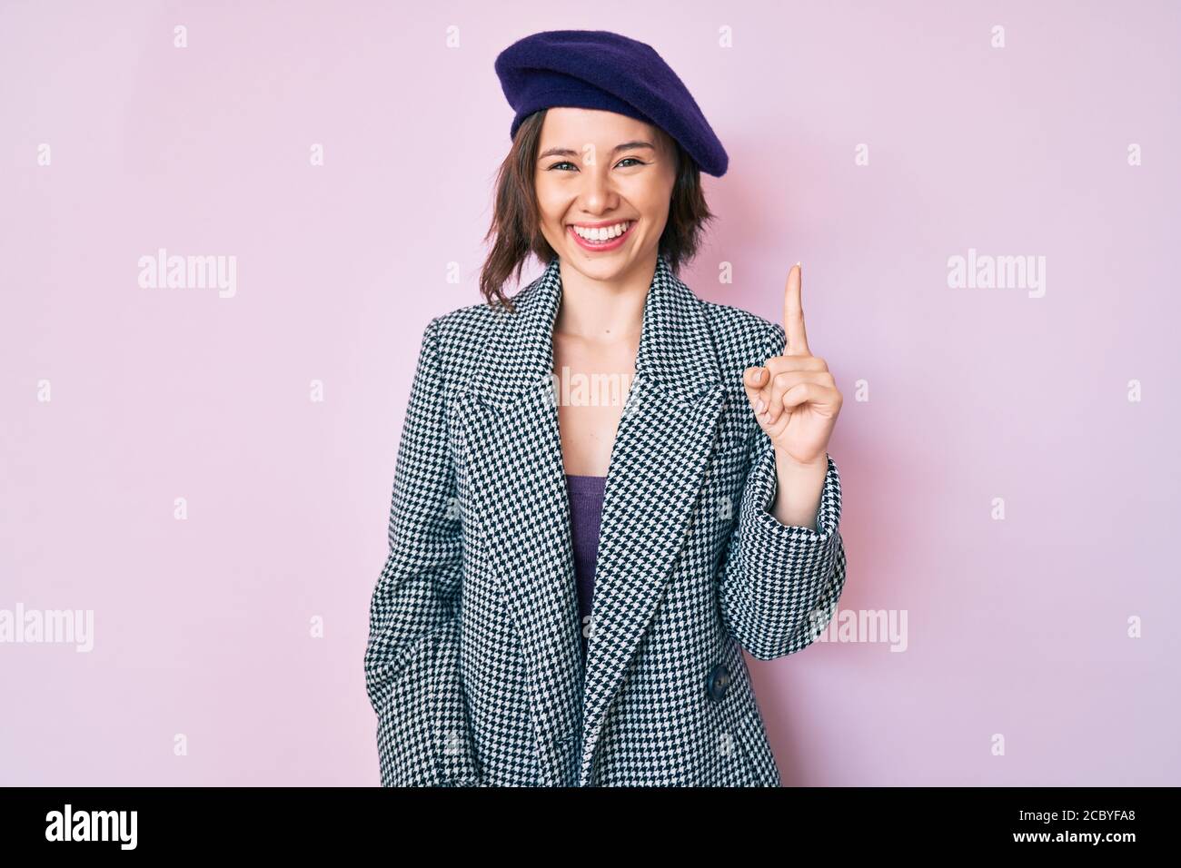 Junge schöne Frau trägt französisch Look mit Baskenmütze zeigt Finger nach  oben mit erfolgreicher Idee. Begeistert und glücklich. Nummer eins  Stockfotografie - Alamy