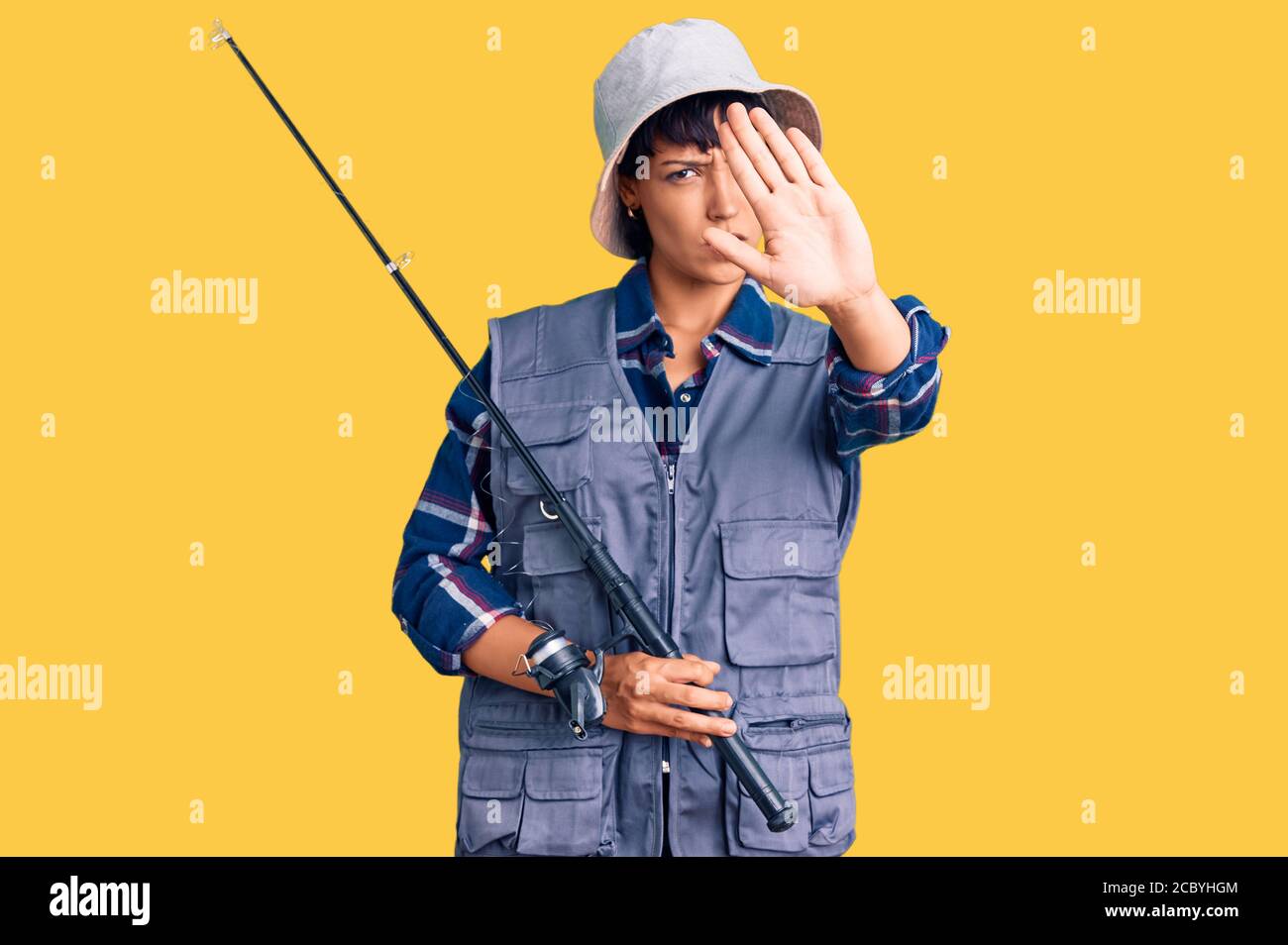 Junge Brünette Frau mit kurzen Haaren trägt Fischer Ausrüstung mit offener Hand tun Stop-Zeichen mit ernsten und selbstbewussten Ausdruck, Verteidigung Geste Stockfoto