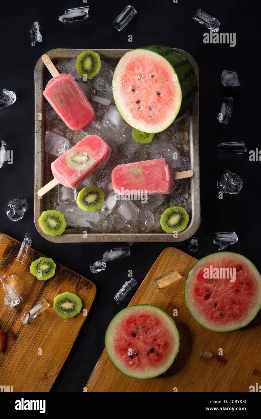 Hausgemachte Wassermelone und Kiwi Eis oder Eis Eis Eis Eis Eis Früchte und Eisstücke auf schwarzem Tisch Stockfoto