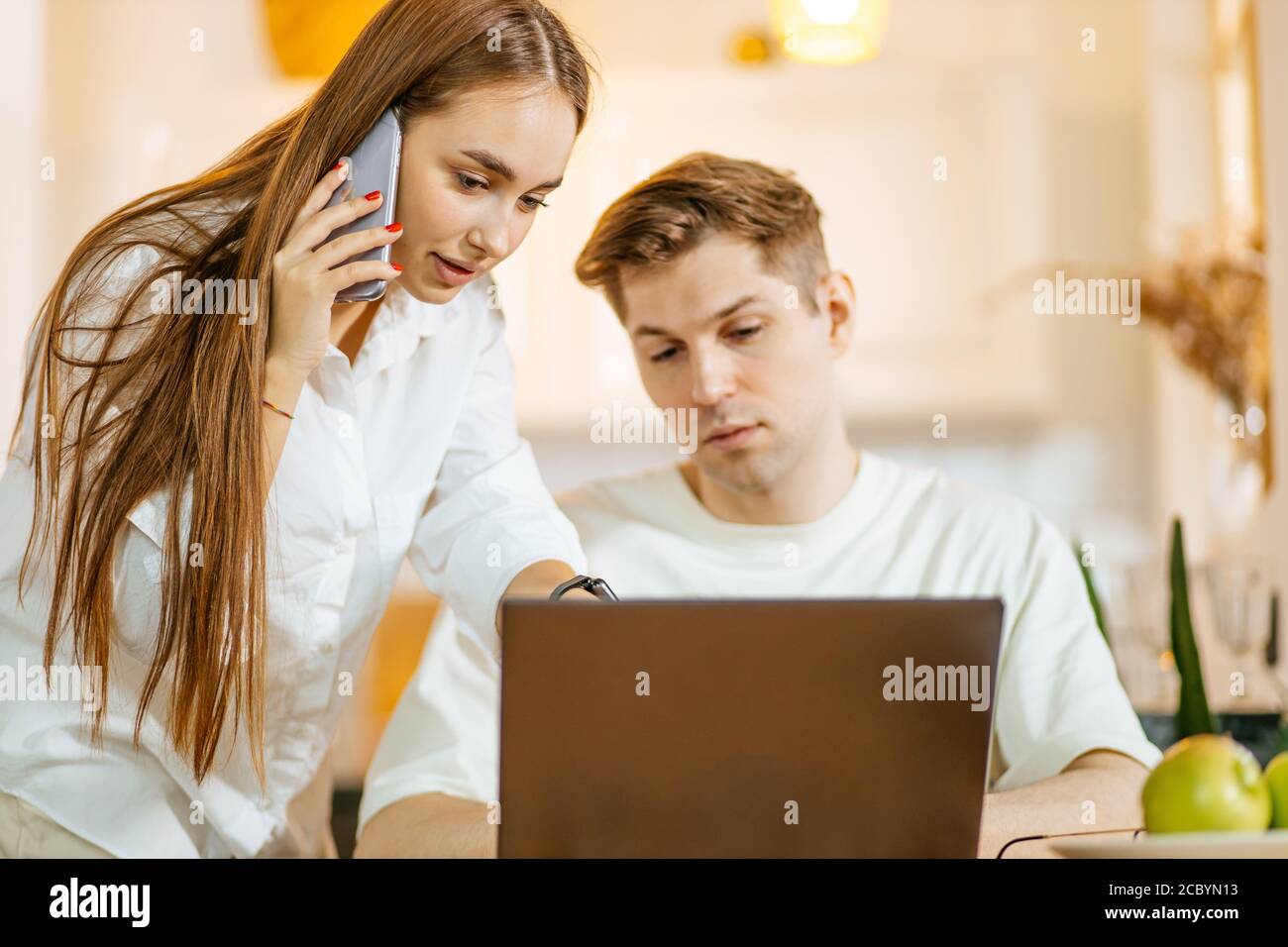 Junge kaukasische Ehepaar auf der Suche nach ihrem ersten Kauf online auf Laptop. Schöne Frau und Mann wollen Hypothek zu bekommen Stockfoto
