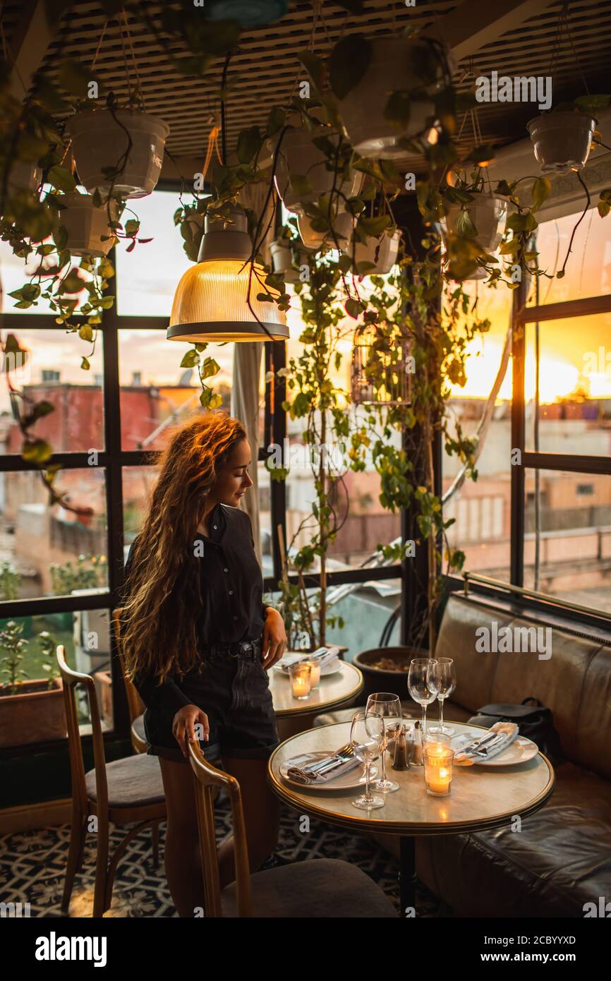 Romantisches Abendessen für schöne Frau. Dachterrasse, Gläser für Wein, Kerzen, Marmortisch. Atmosphäre der Liebe. Stockfoto