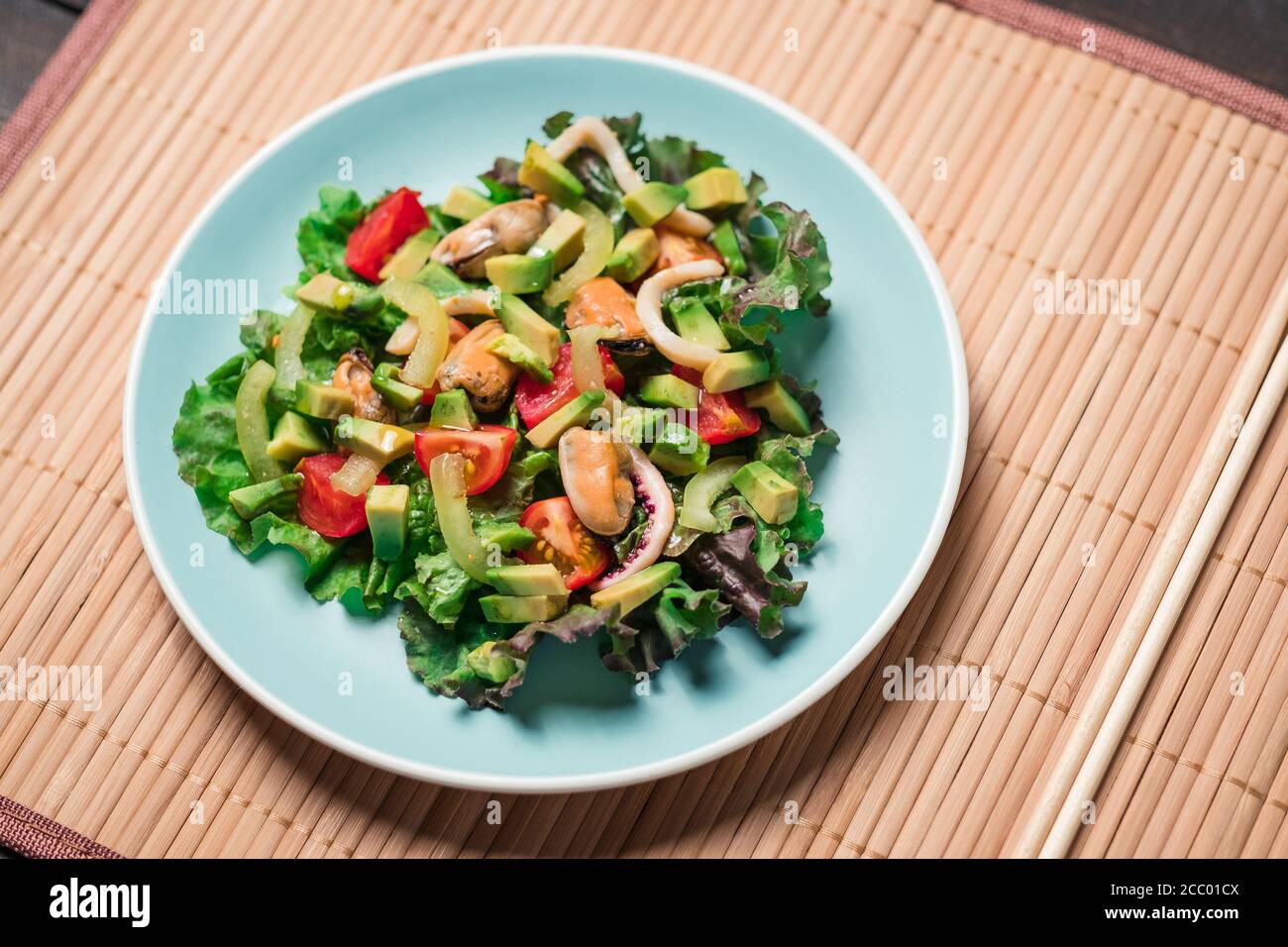 Draufsicht - Salat mit Meeresfrüchten auf Farbteller Stockfoto