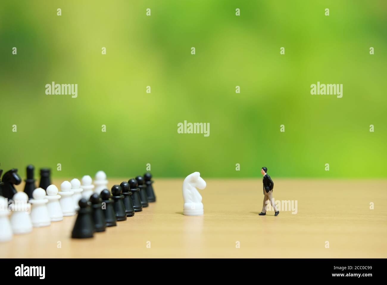 Business-Strategie konzeptuelles Foto - Miniatur des Geschäftsmannes zu Fuß Ein Pferdeschachstück Stockfoto