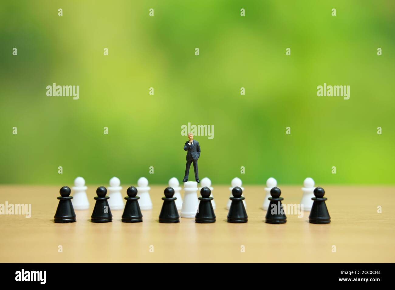 Miniatur-Leute strategisches Konzept - Geschäftsmann, der über Schachpfand steht Stockfoto