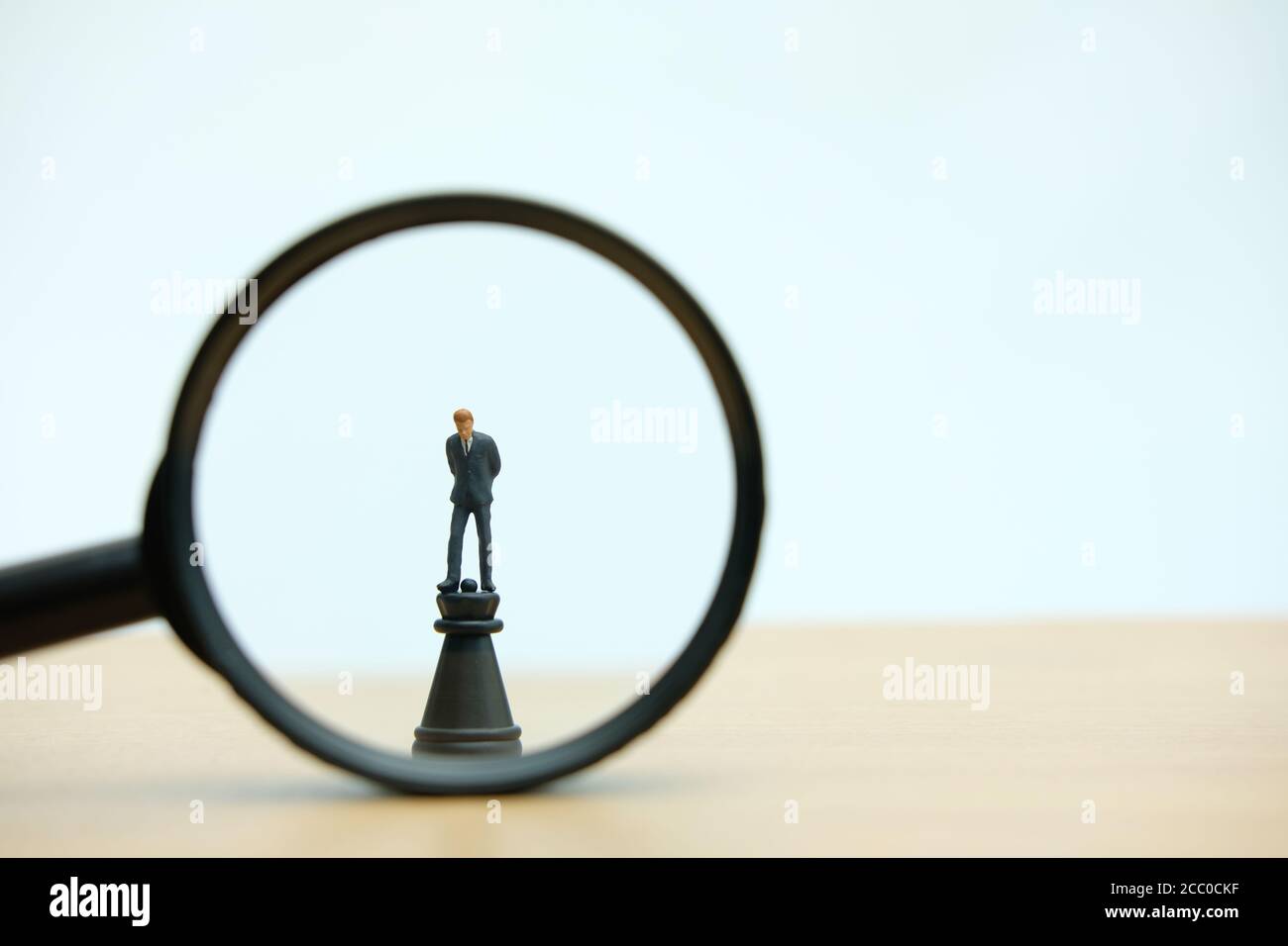 Miniatur Menschen strategisches Konzept - Vergrößerungsglas ein Geschäftsmann stehen über Burgschach-Bauer Stockfoto