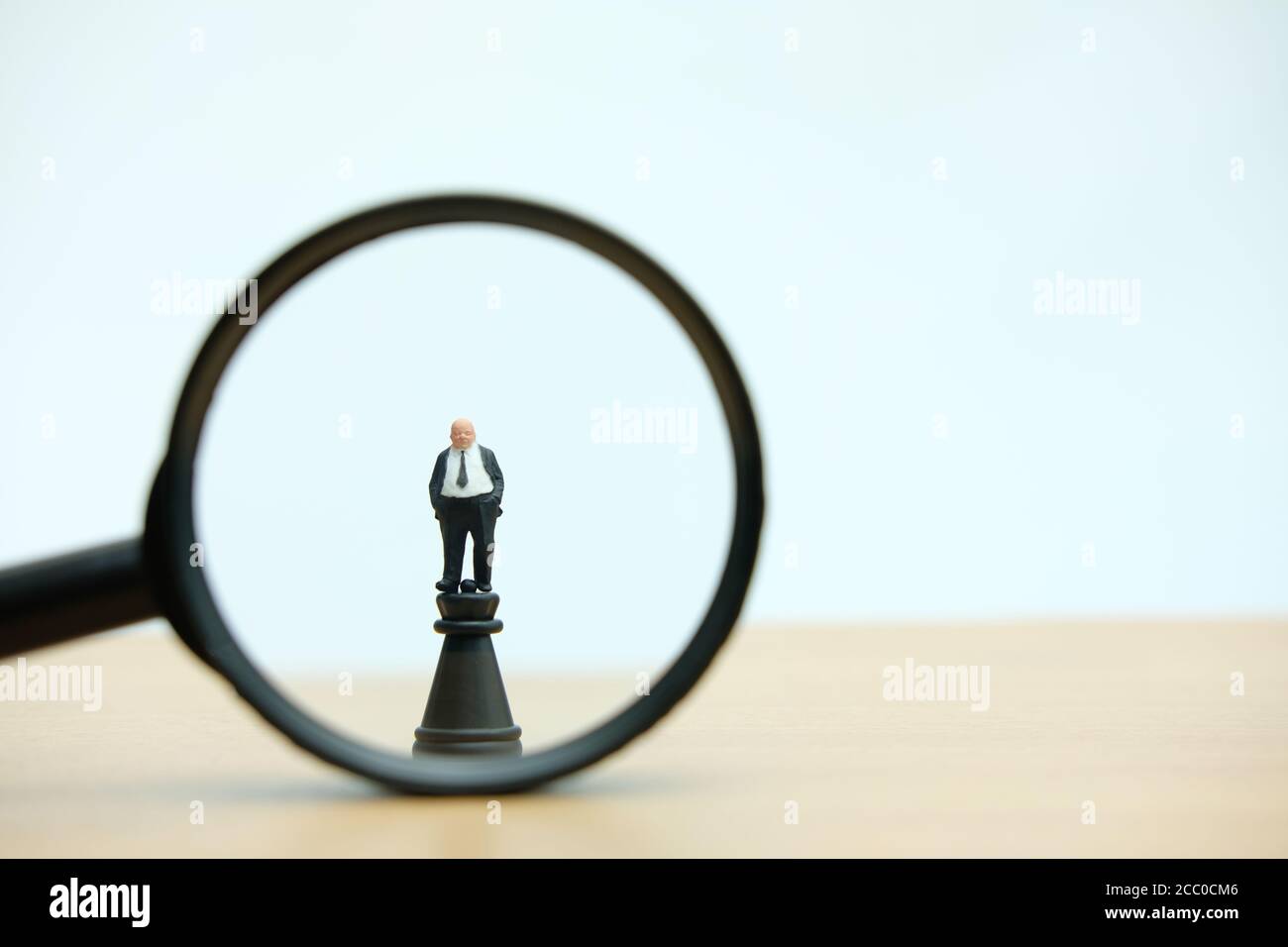 Miniatur Menschen strategisches Konzept - Vergrößerung eines großen Chef Geschäftsmann Steht über Burg Schachfigur Stockfoto