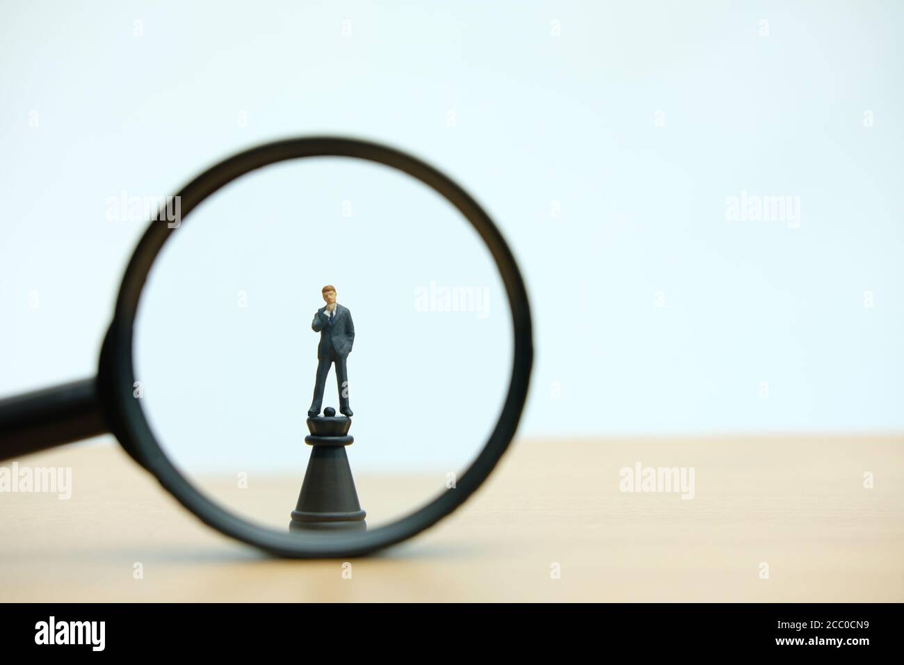Miniatur Menschen strategisches Konzept - Vergrößerungsglas ein Geschäftsmann stehen über Burgschach-Bauer Stockfoto