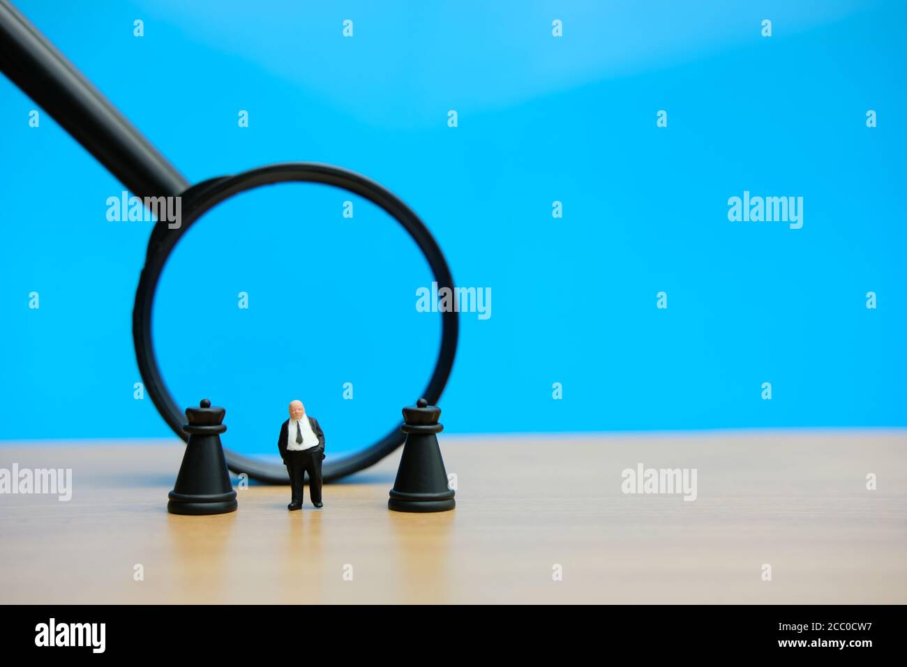 Miniatur Menschen strategisches Konzept - Geschäftsmann steht zwischen Schloss Schach Vor der Lupe gepfändet Stockfoto