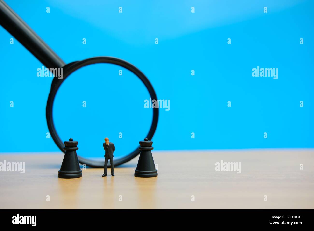 Miniatur Menschen strategisches Konzept - Geschäftsmann steht zwischen Schloss Schach Vor der Lupe gepfändet Stockfoto