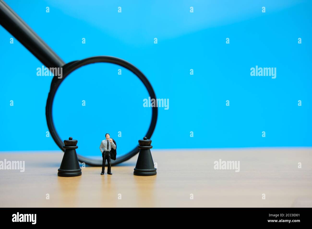 Miniatur Menschen strategisches Konzept - Geschäftsmann steht zwischen Schloss Schach Vor der Lupe gepfändet Stockfoto