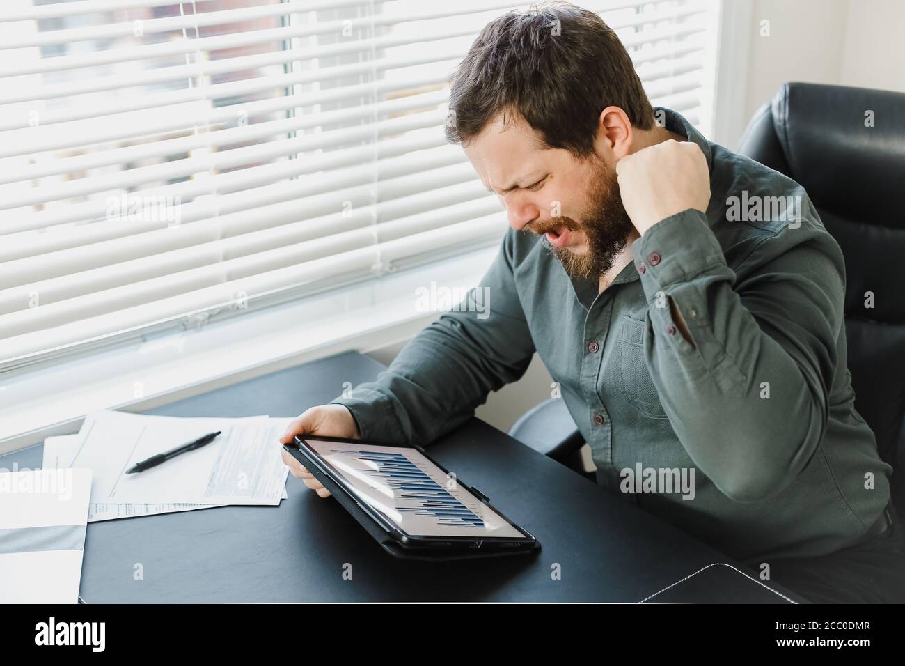Serious männlichen Unternehmer mit digitalen Tablet und die Arbeit mit Dokumenten. Stockfoto