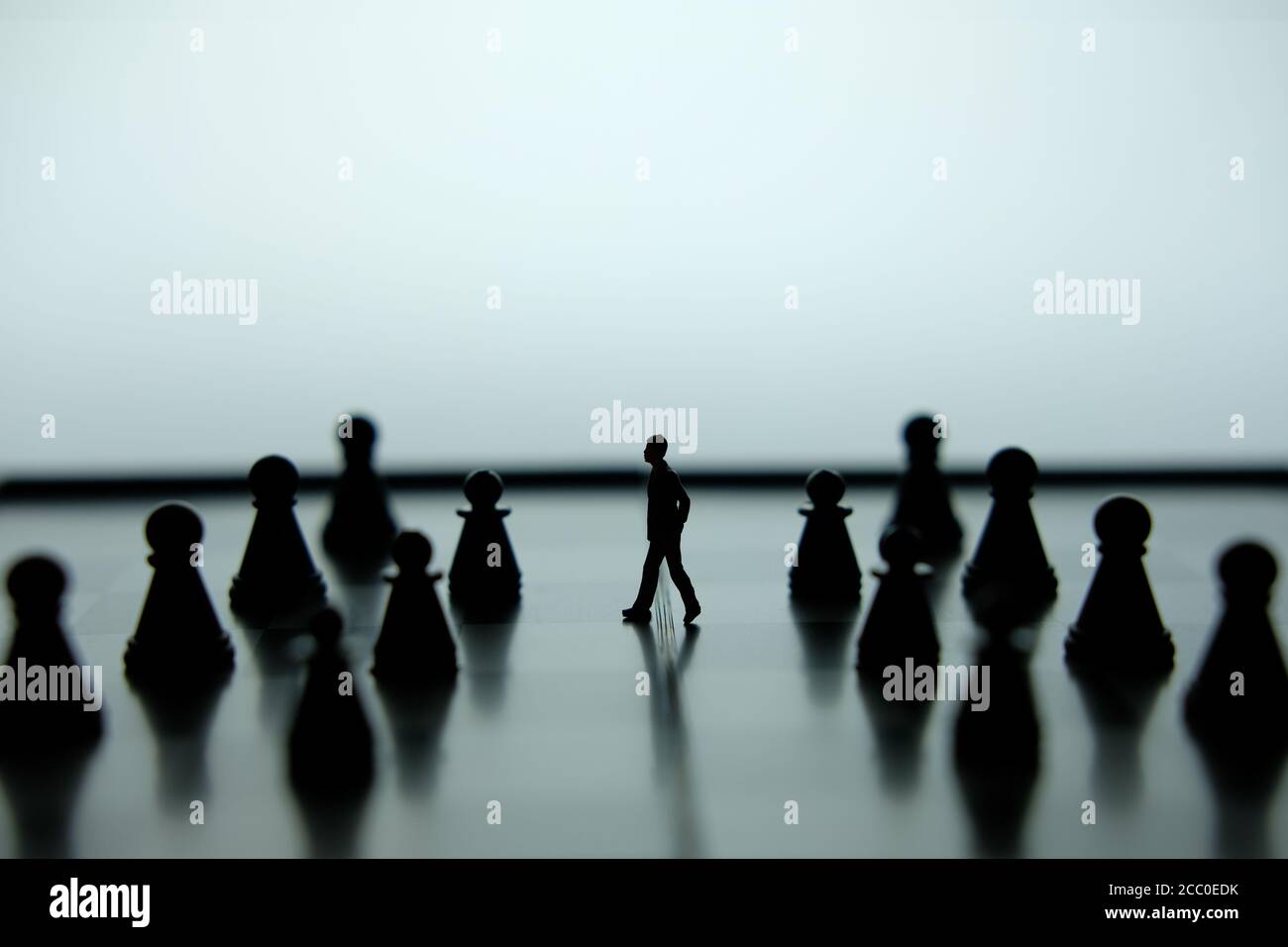 Business-Strategie konzeptuelles Foto - Miniatur des Geschäftsmannes, der vorwärts geht In der Mitte des Schachspiels auf einem Schachbrett Stockfoto