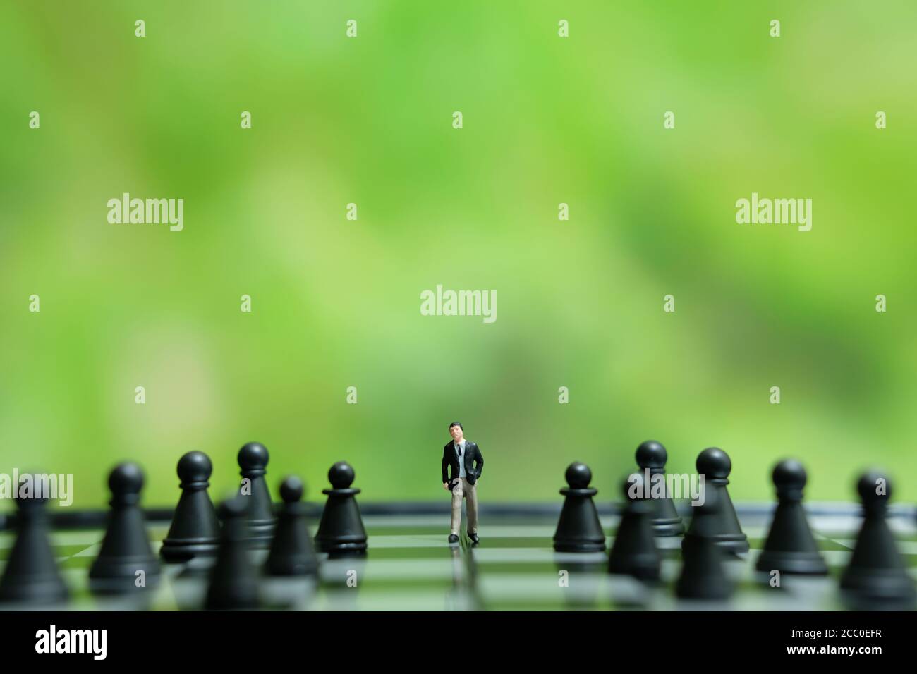 Business-Strategie konzeptuelles Foto - Miniatur des Geschäftsmannes, der vorwärts geht In der Mitte des Schachspiels auf einem Schachbrett Stockfoto