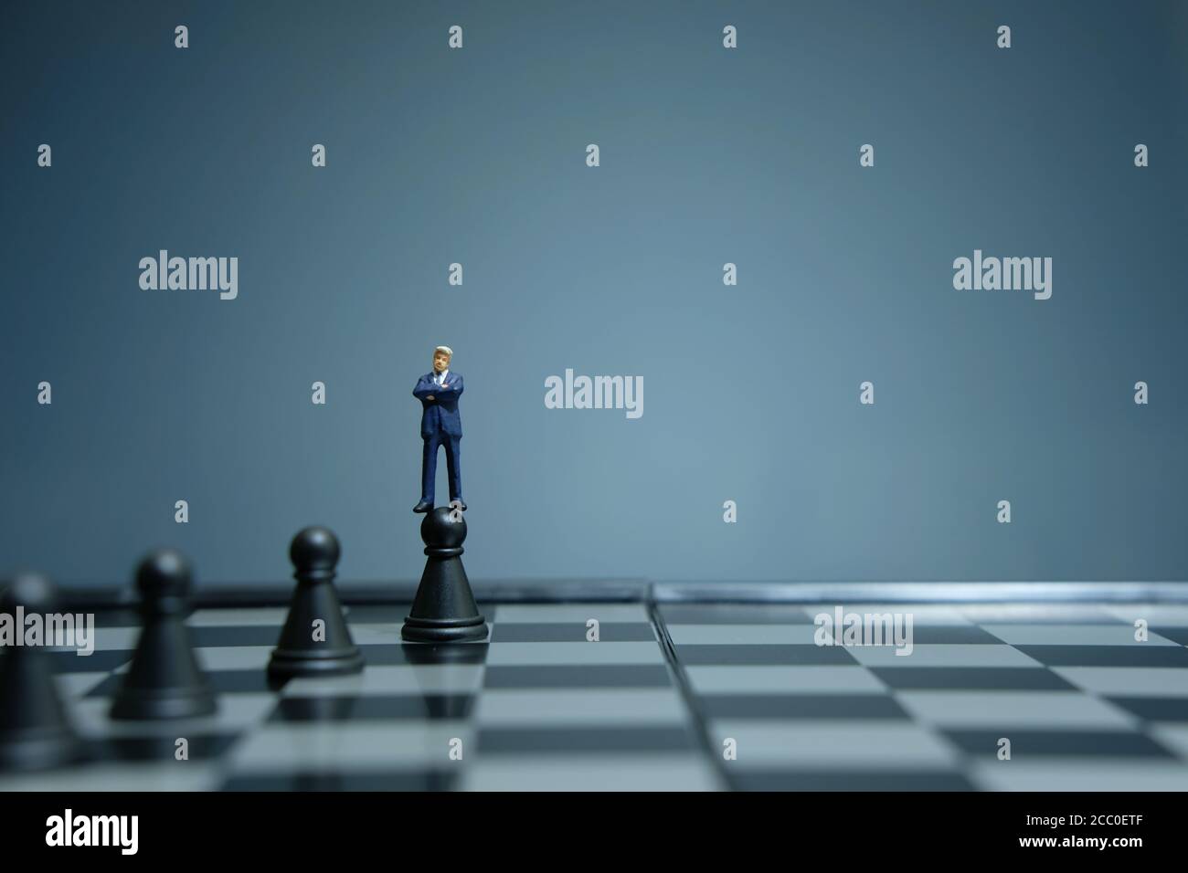 Business-Strategie konzeptuelles Foto - Miniatur Geschäftsmann über Schloss stehen Bauer auf einem Schachbrett Stockfoto