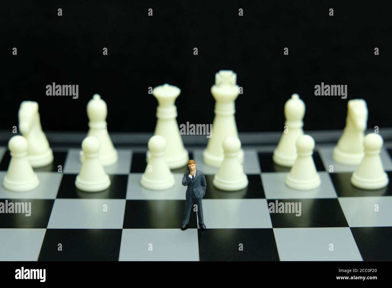 Business-Strategie konzeptuelles Foto - Miniatur des Geschäftsmannes stehend auf Schachbrett Stockfoto