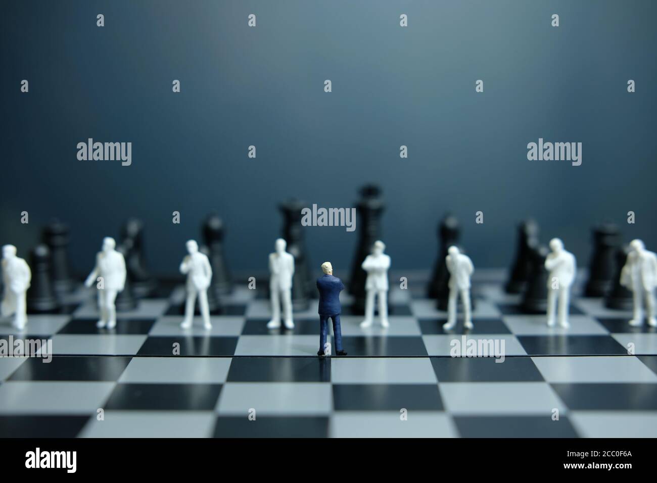 Business-Strategie konzeptuelles Foto - Miniatur des Geschäftsmannes stehend auf Schachbrett Stockfoto