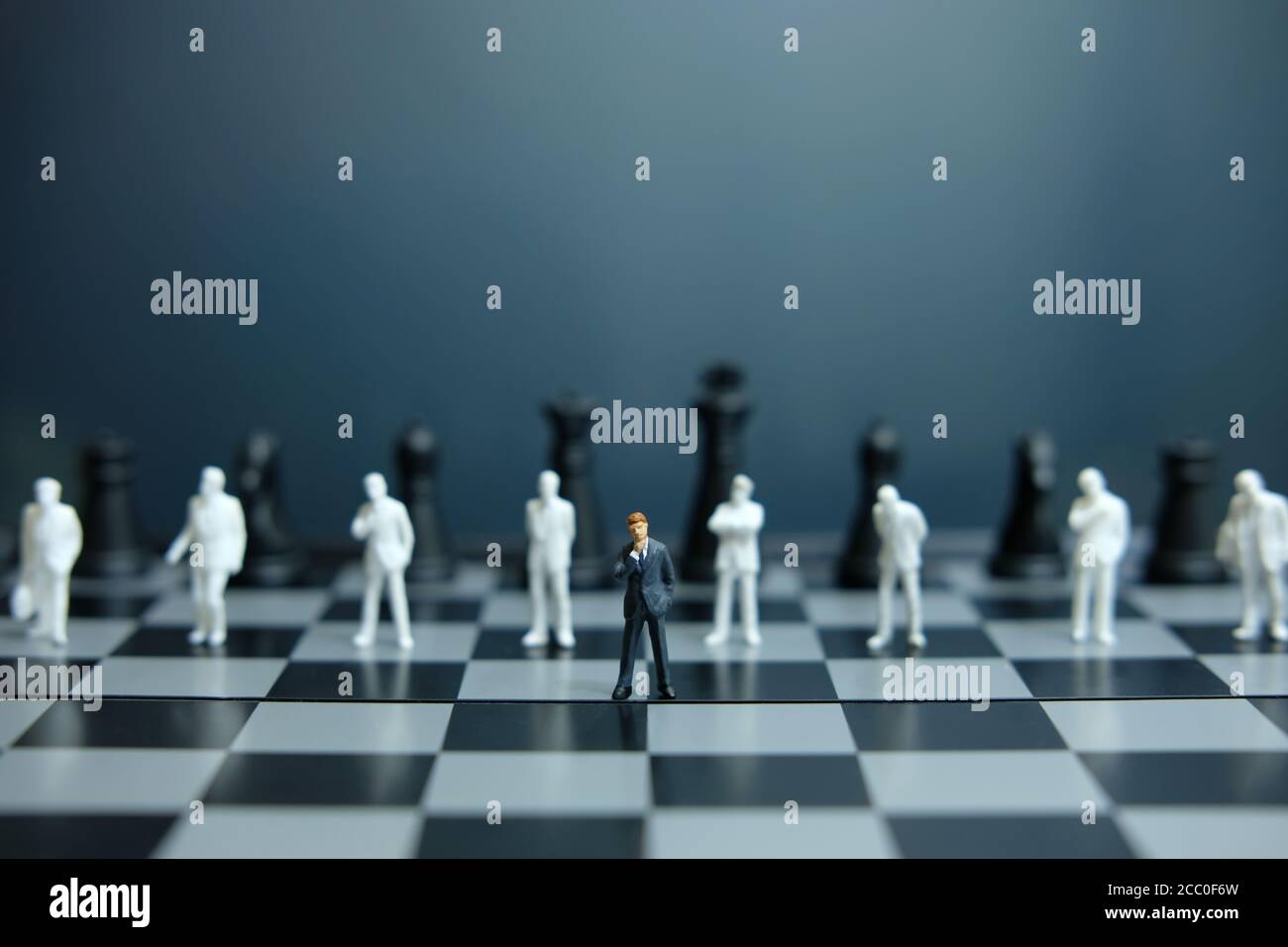 Business-Strategie konzeptuelles Foto - Miniatur des Geschäftsmannes stehend auf Schachbrett Stockfoto