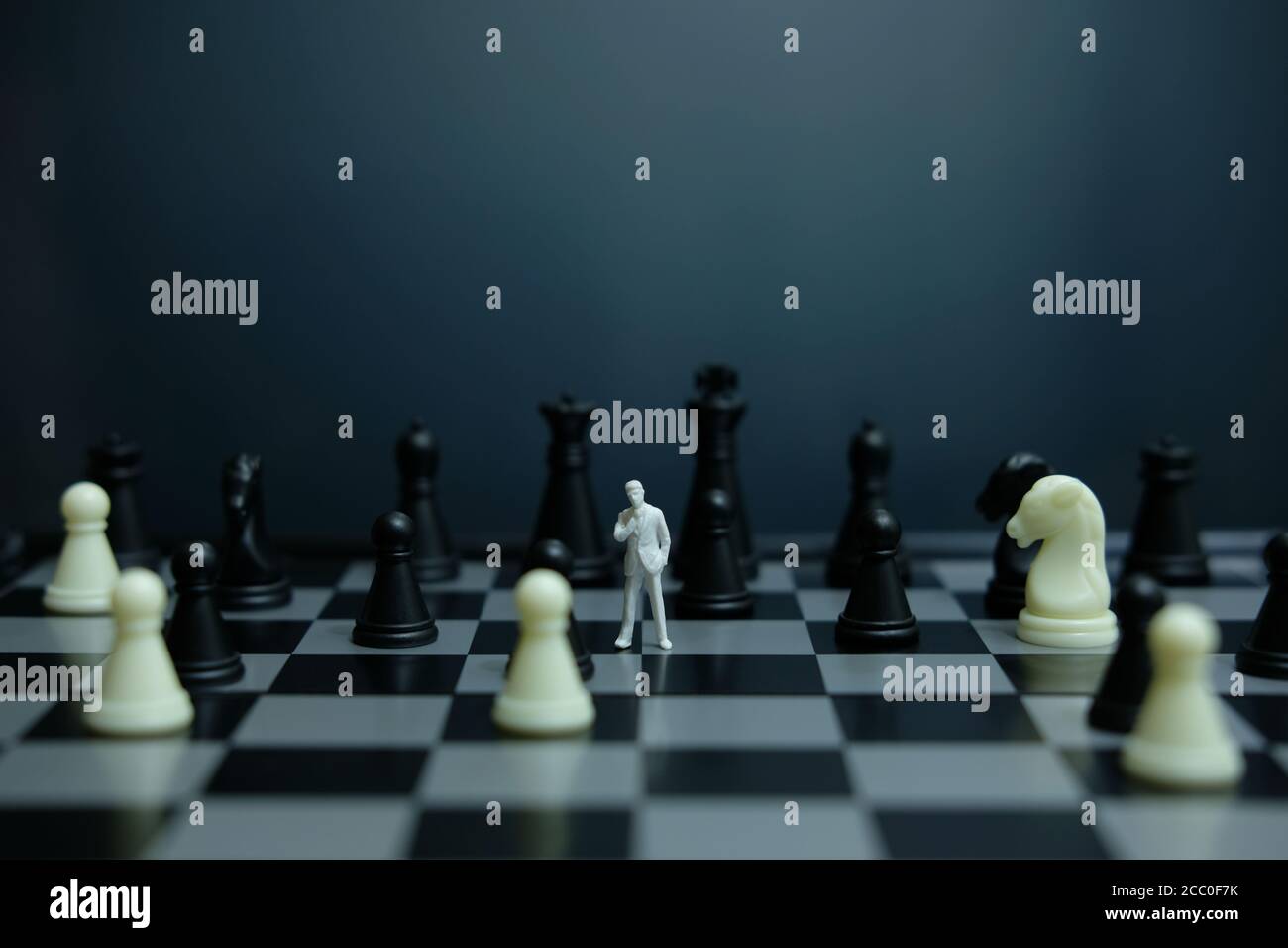 Business-Strategie konzeptuelles Foto - Miniatur des Geschäftsmannes stehend auf Schachbrett Stockfoto