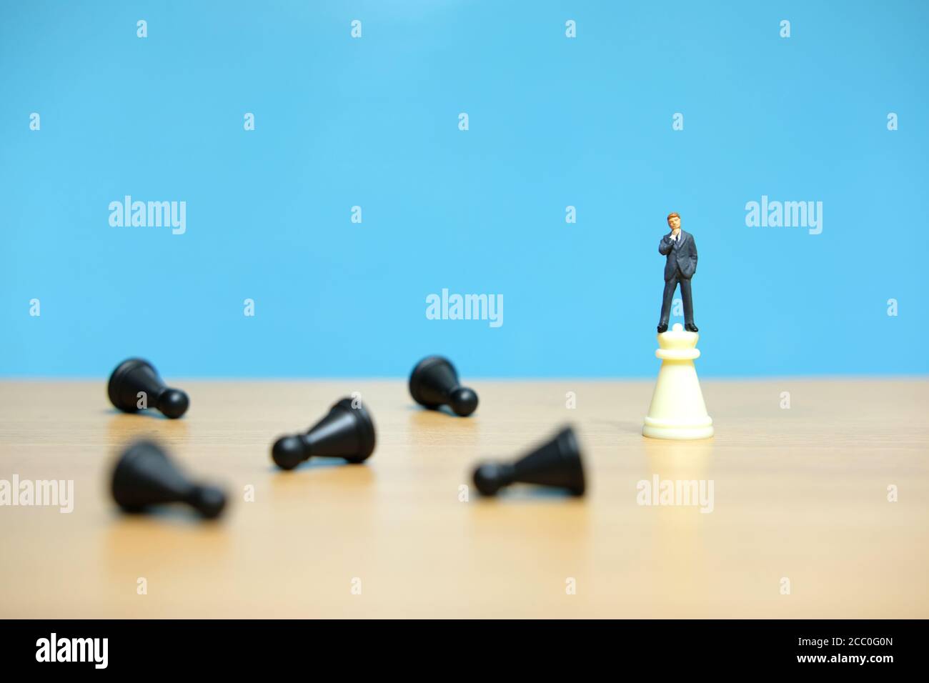 Business-Strategie konzeptionelle Foto - Miniatur Geschäftsmann auf Schloss stehen Schachfigur zwischen fallendem Schachstück Stockfoto