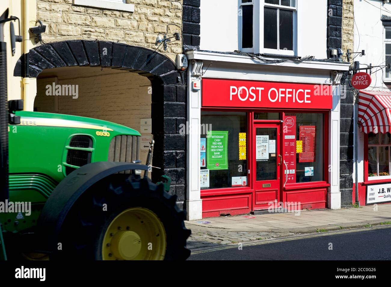 Traktor am Postamt in der High Street, Wetherby, West Yorkshire, England vorbei Stockfoto