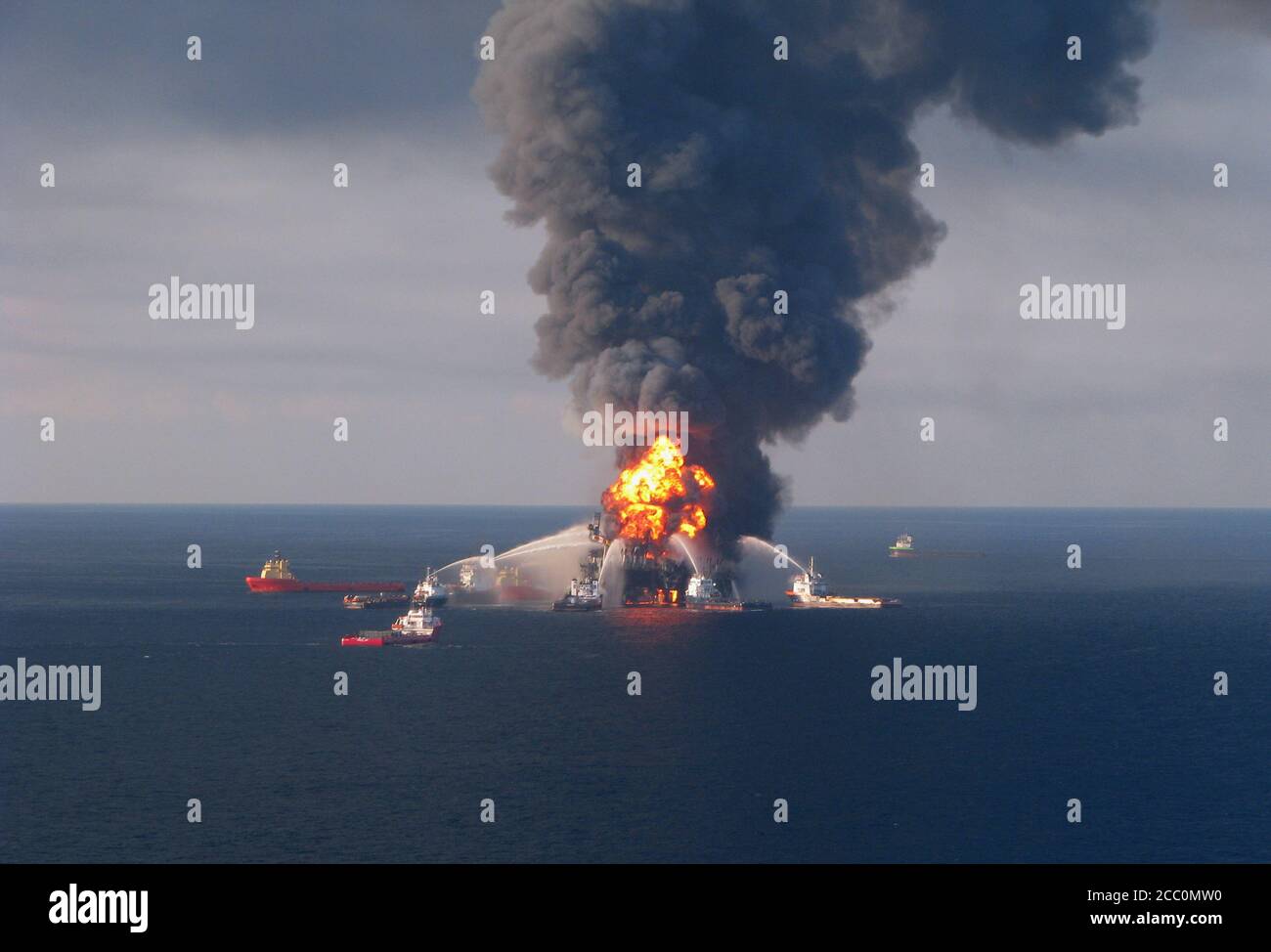 GOLF VON MEXIKO, USA - 21. April 2010 - Plattformversorgungsschiffe kämpfen gegen die brennenden Überreste der Offshore-Ölplattform Deepwater Horizon. Ein Küstenwache MH Stockfoto