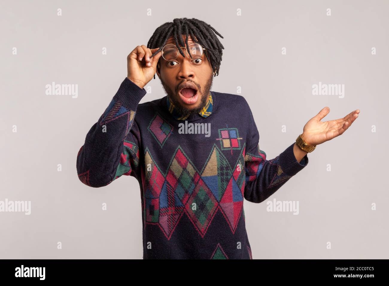 Extrem erstaunt und schockiert afrikanischen Mann mit Bart und Dreadlocks Blick auf die Kamera mit weit geöffneten Augen und Mund, überrascht und verwirrt mit ne Stockfoto