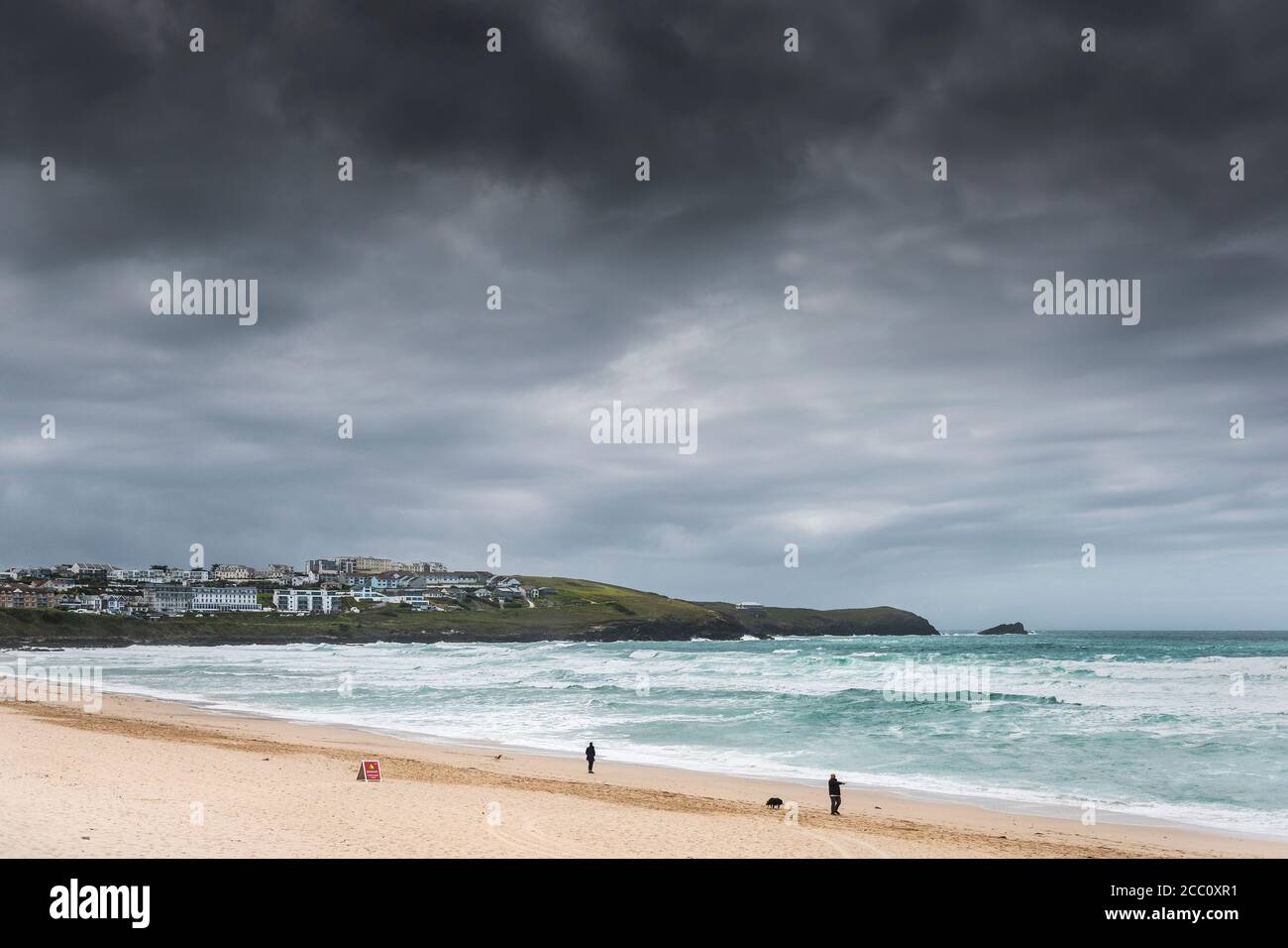 Dunkle Wolken sammeln sich über einem windigen Fistral Beach in Newquay in Cornwall. Stockfoto