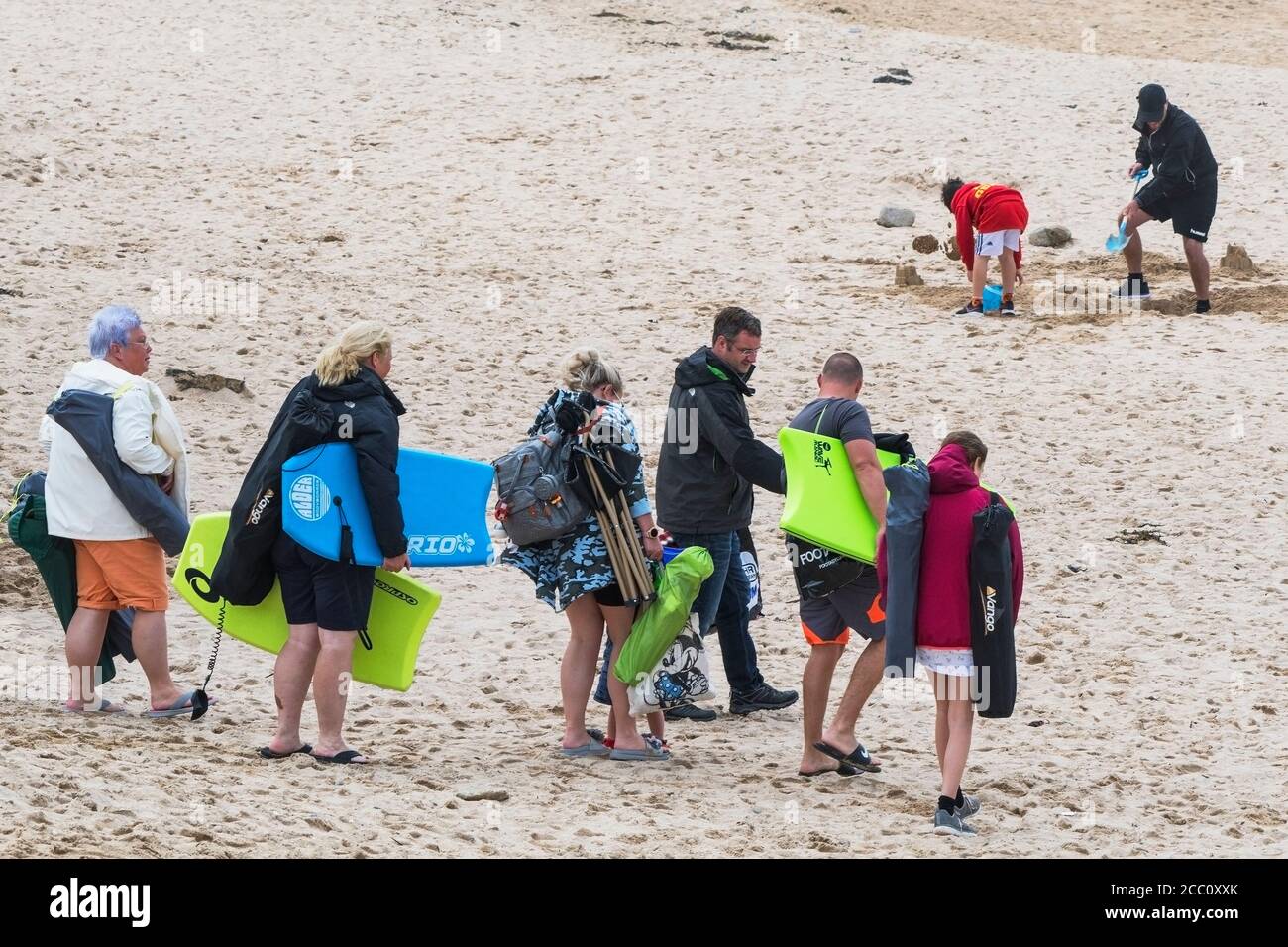 Eine Familie britischer Urlauber, die für einen Tag am Fistral Beach in Newquay in Cornwall ankommen. Stockfoto