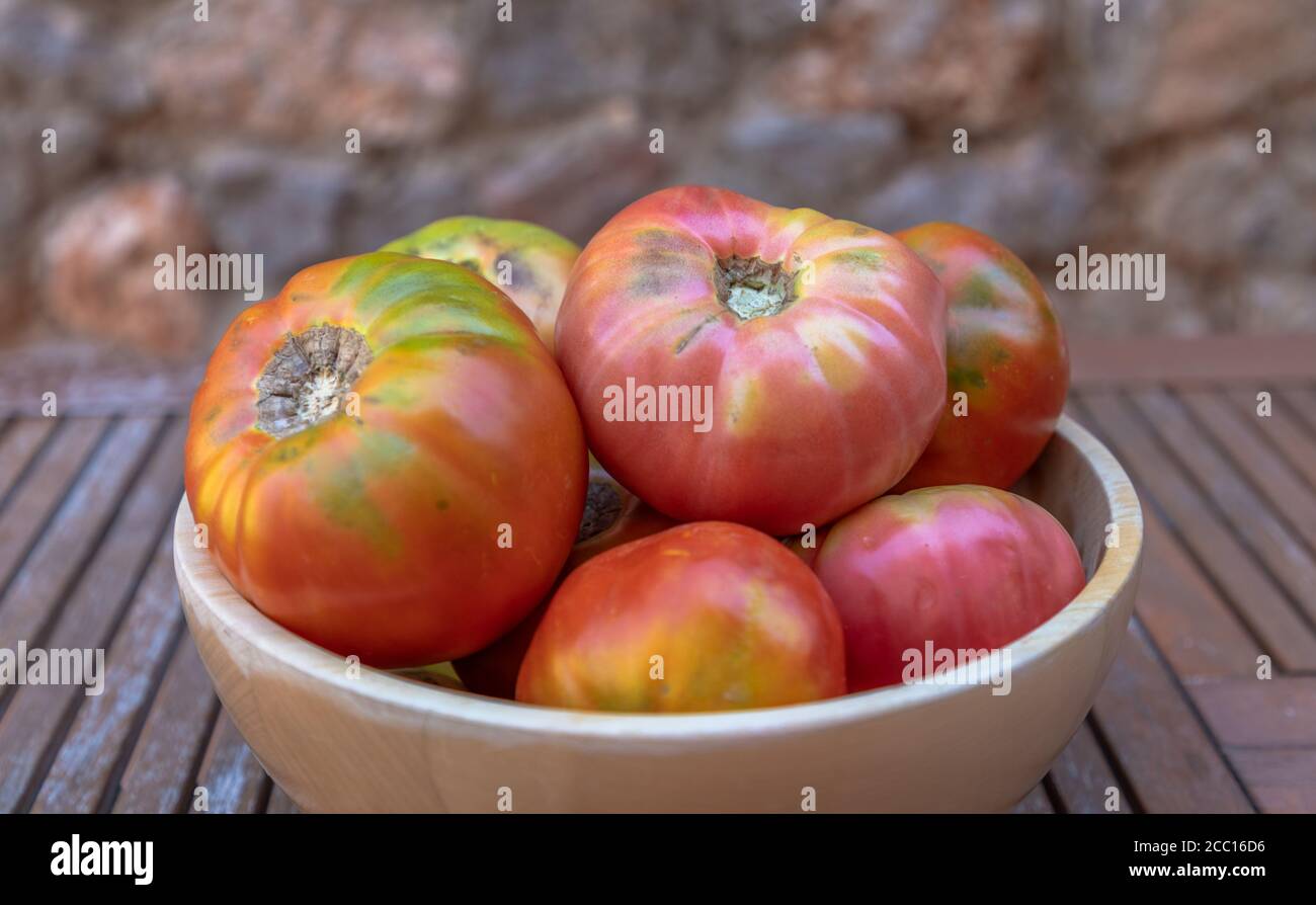 Eine Schüssel voll mit frischen Moruno Tomaten in einem hölzernen Hintergrund Stockfoto