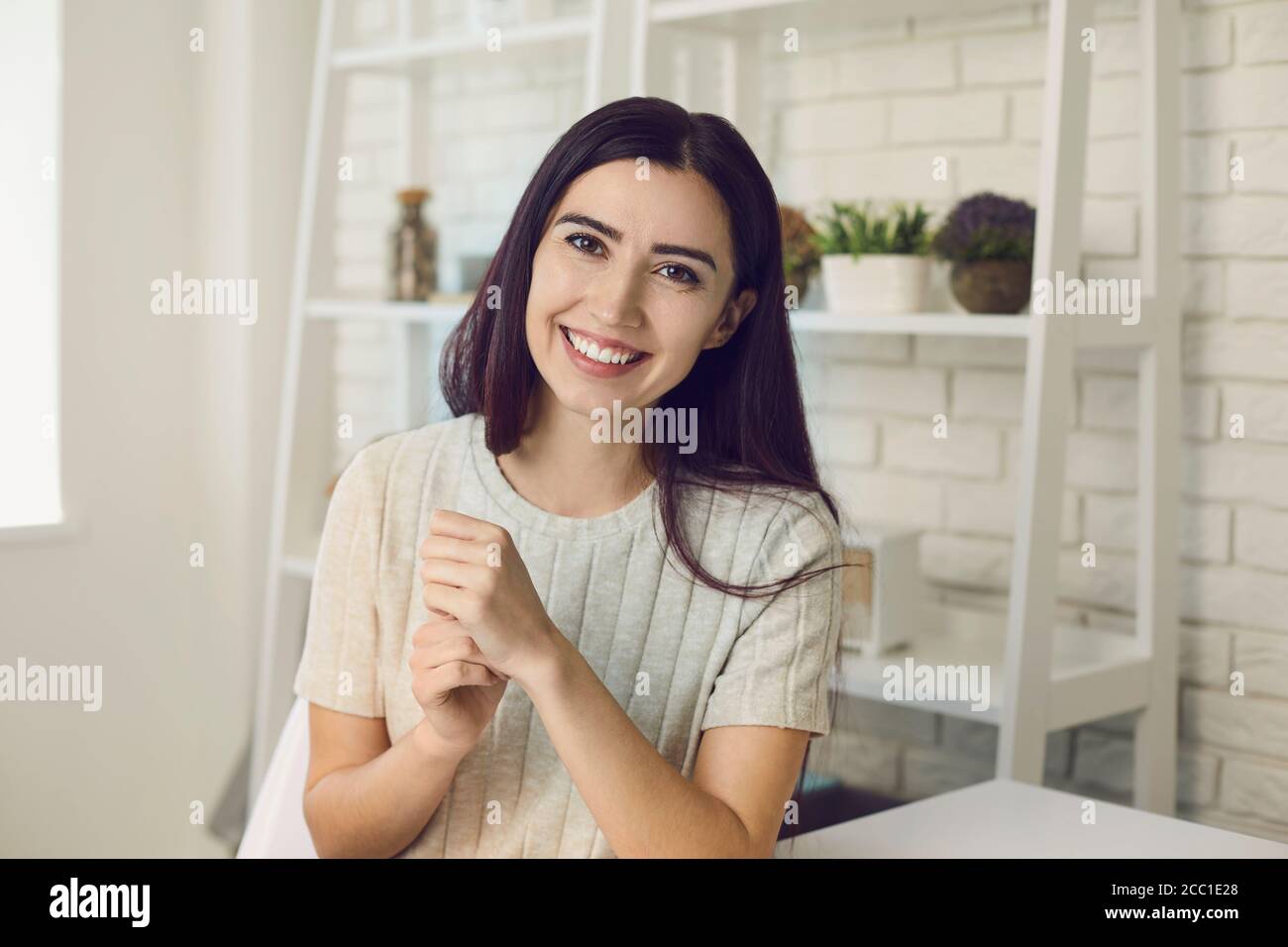 Charmante Frau sitzt am Tisch in Loft-Stil Wohnung Stockfoto