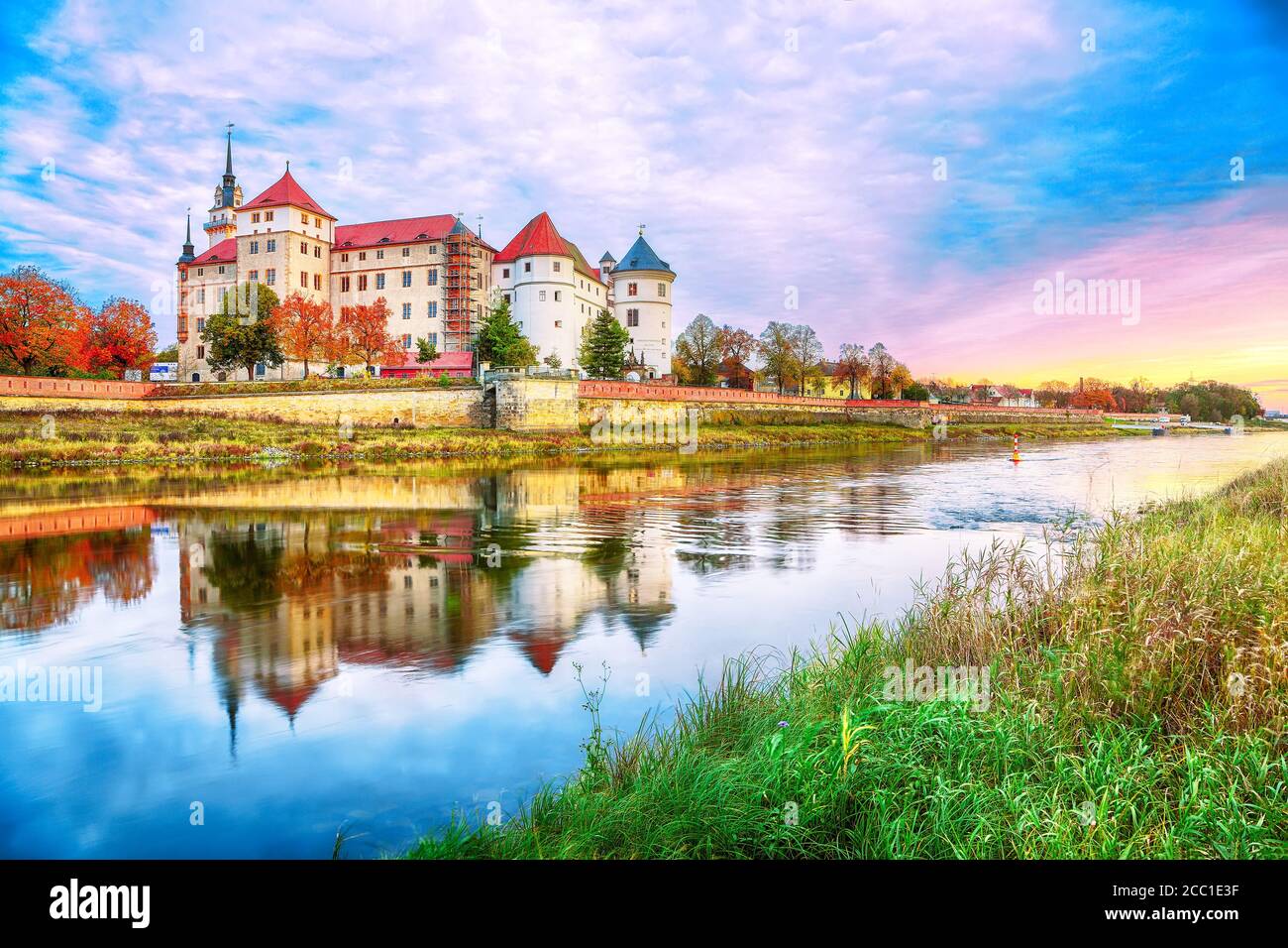 Fantastische Morgenansicht auf Schloss Hartenfels am Ufer der Elbe. Dramatischer Sonnenaufgang. Standort: Torgau, Nordwest-Sachsen, Deutschland, Europa Stockfoto