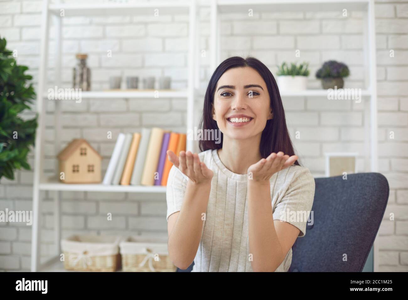 Content Frau macht Luft Kuss Geste im Wohnzimmer Stockfoto