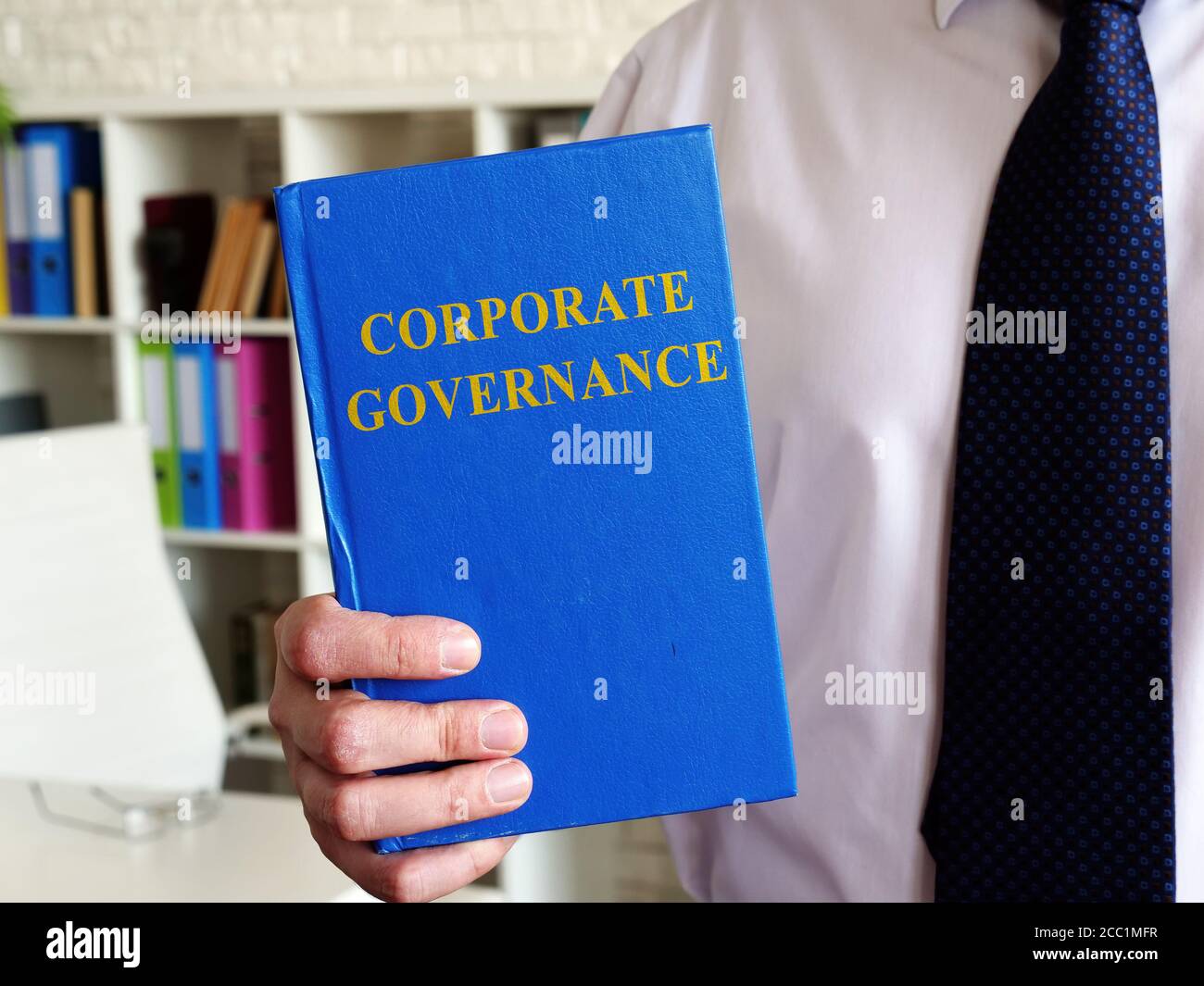 Corporate Governance-Konzept. Der Büroangestellte zeigt ein Buch. Stockfoto