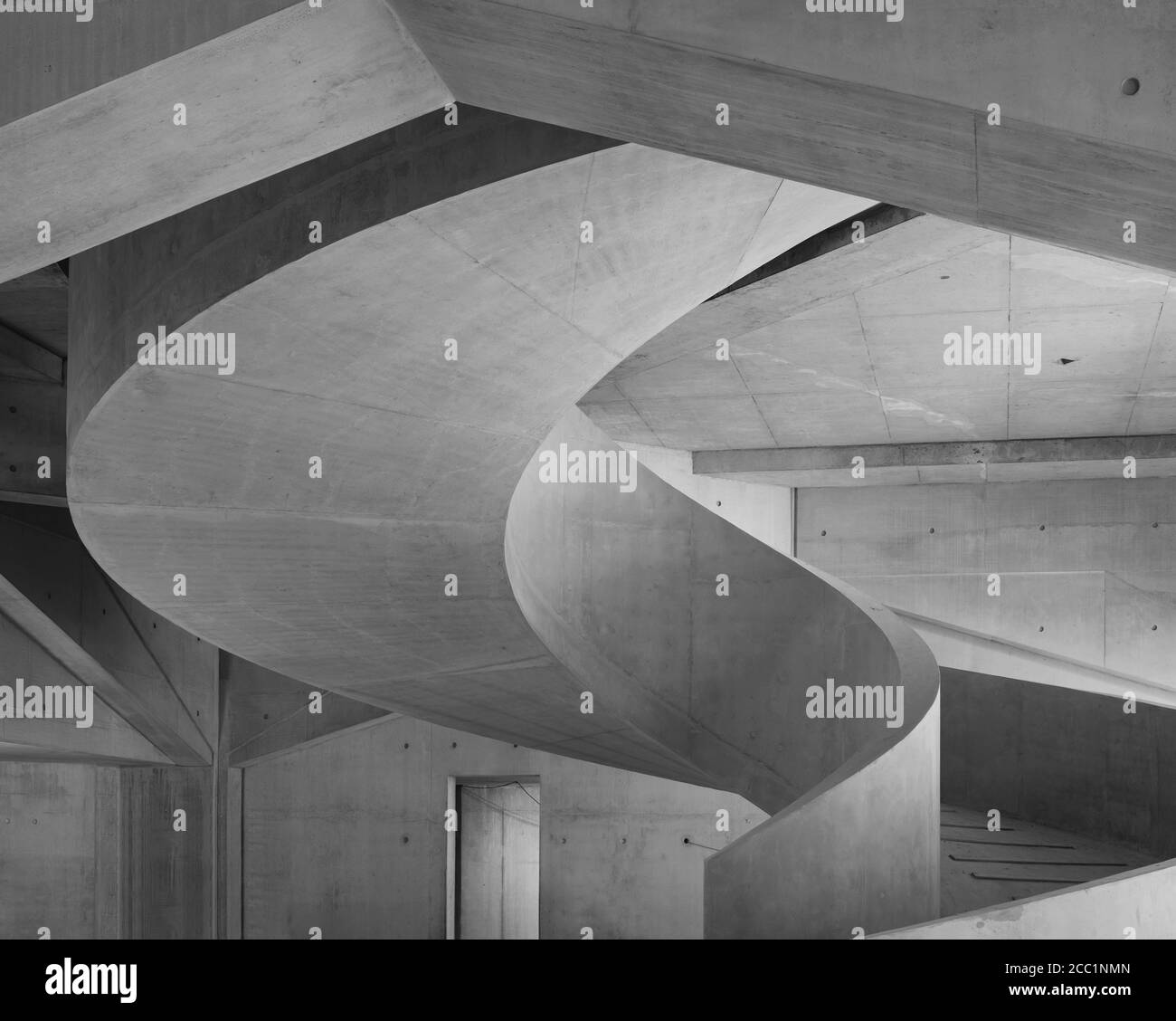 Schwarz-weiße Erdgeschossansicht der Wendeltreppe aus Beton. The Marshall Building LSE, London, Vereinigtes Königreich. Architekt: Grafton Architects, 2021. Stockfoto